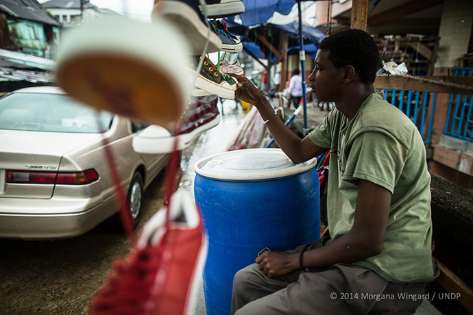  Ibrahim, 20, sells shoes in Waterside Market in downtown Monrovia on Sept. 18, 2014. Normally at this time of year he sells shoes for students going back to school. On a typical day he would sell between two and five pairs. Since the Ebola virus epi