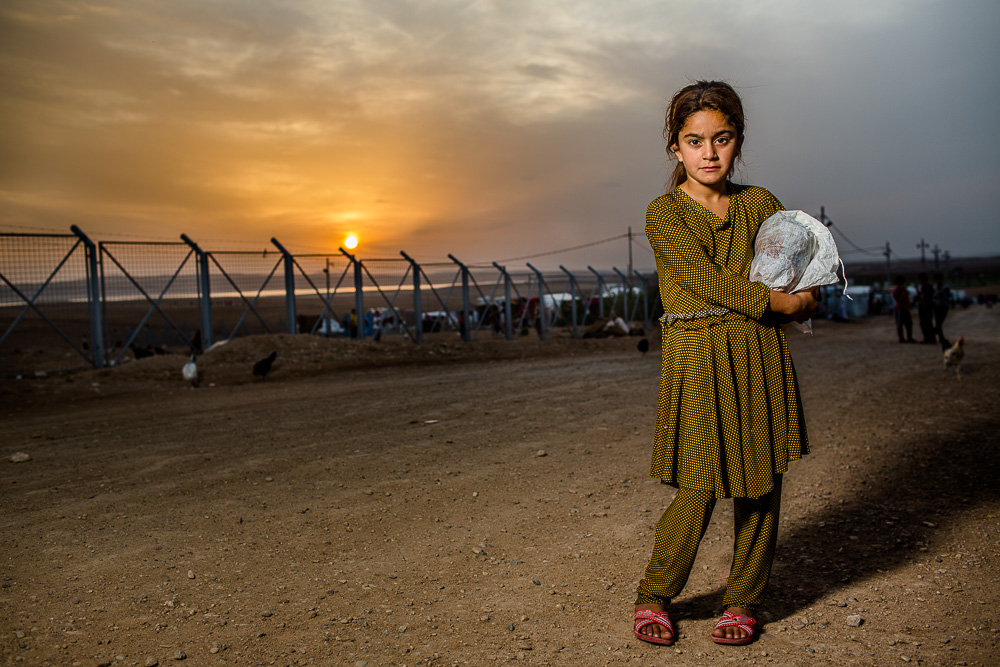 Yazidi refugee in Khanke refugee camp in northern Iraq. In case you missed it, like me, the Islamic State seized towns in Sinjar on August 3 - 4, 2014. Families fled in the middle of the night to the mountain and hid for 7 - 10 days before running out of resources and walking by foot to the nearest town. Many traveled to Syria before coming back into Kurdistan and eventually settling in refugee camps in Northern Iraq. There are several camps like this one that house approximately 20,000 people. Outside another 30 - 40,000 people have setup makeshift tents, but lack the services (including toilets, water, and showers) found inside the camps. 