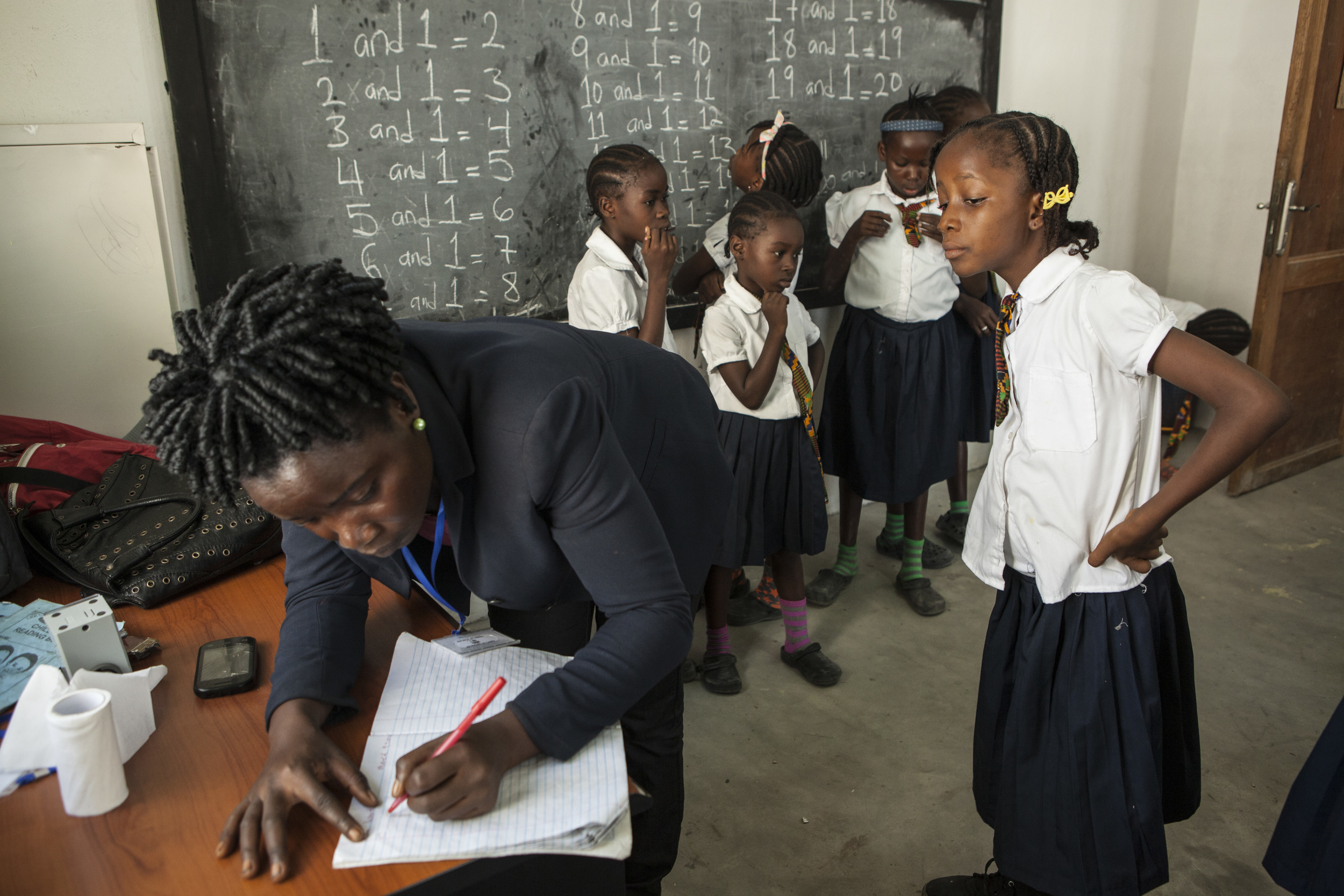MONROVIA, LIBERIA - March 10, 2015: Mercy Kennedy, 9, is seen at the More Than Me Academy and in the school vehicle that takes her home. This is Mercy's first year attending school.