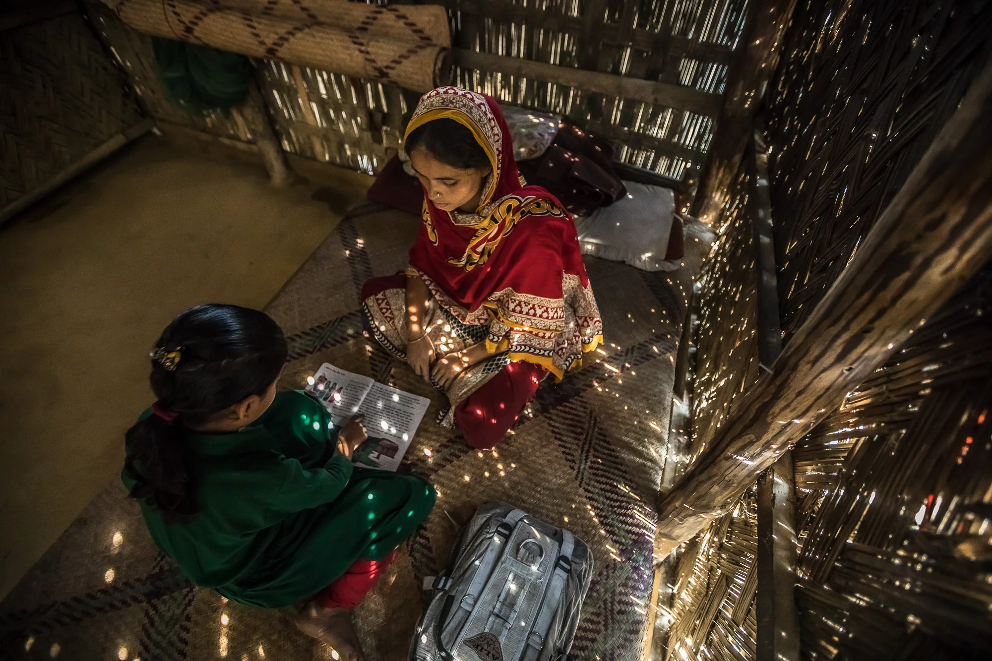 COX'S BAZAR, BANGLADESH: October 25, 2016 - Joynur Jahan Joba, 10, brings her books home from school and reads with her mother. Photo by Morgana Wingard