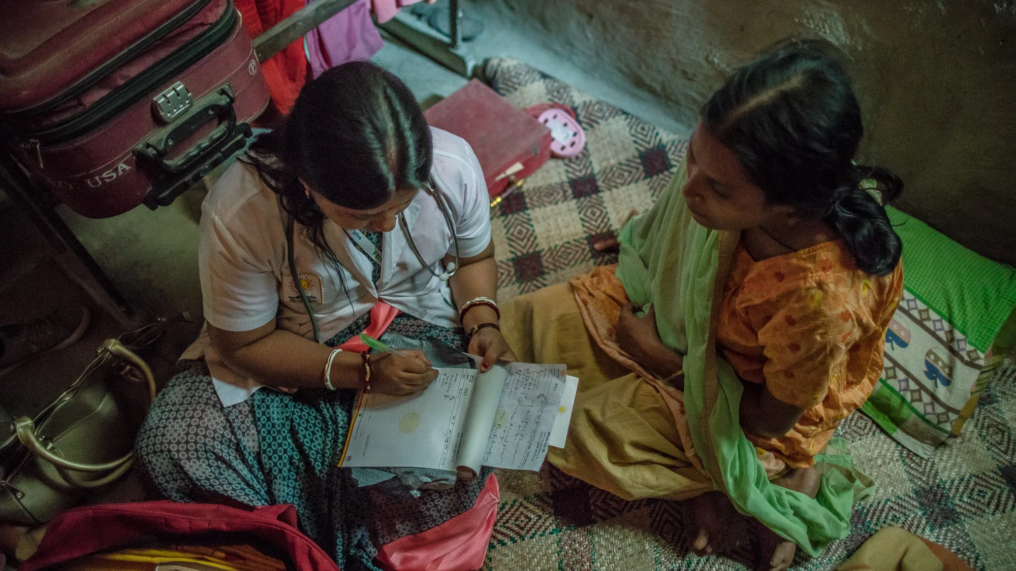 Shanta Das, a paramedic at Smiling Sun Clinic, consults a pregnant mother at her home