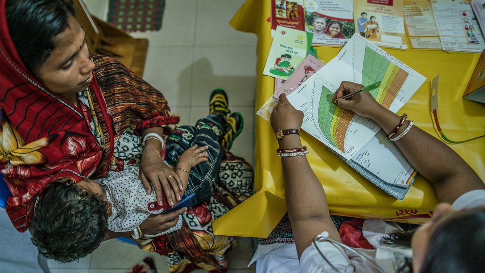  Supriya Dae and her son visit paramedic, Shanta Das, for a checkup on his growth.&nbsp; 