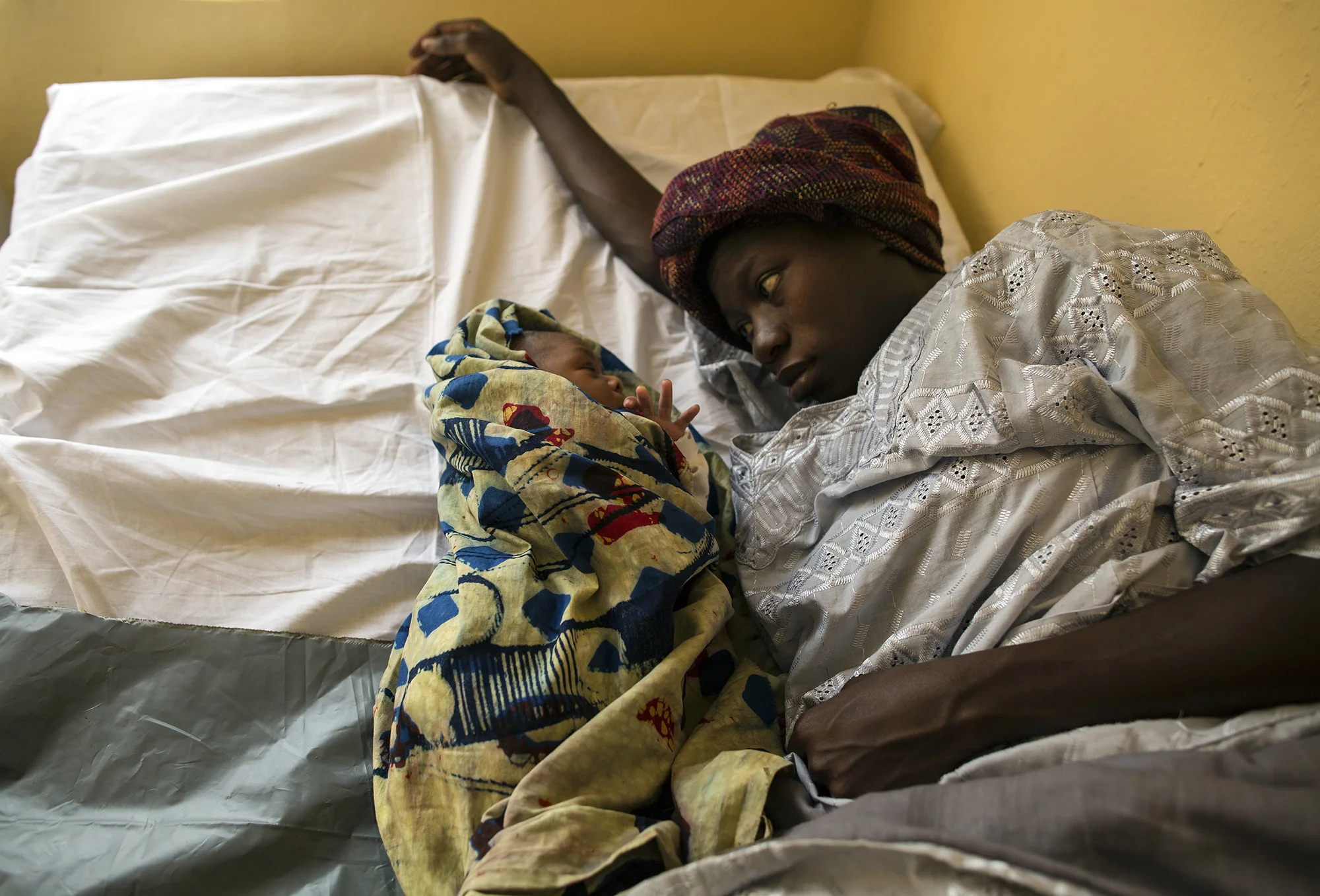  A mother rests with her newborn baby shortly after giving birth and Konsho CHP.&nbsp; 