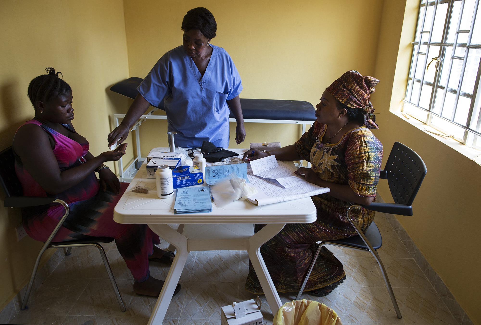  Zainab Tity Sawaneh, center, Maternal and Child Health Aide, Konsho CHP, speaks with Aminata Kalokoh, left, during an antenatal appointment.&nbsp; 