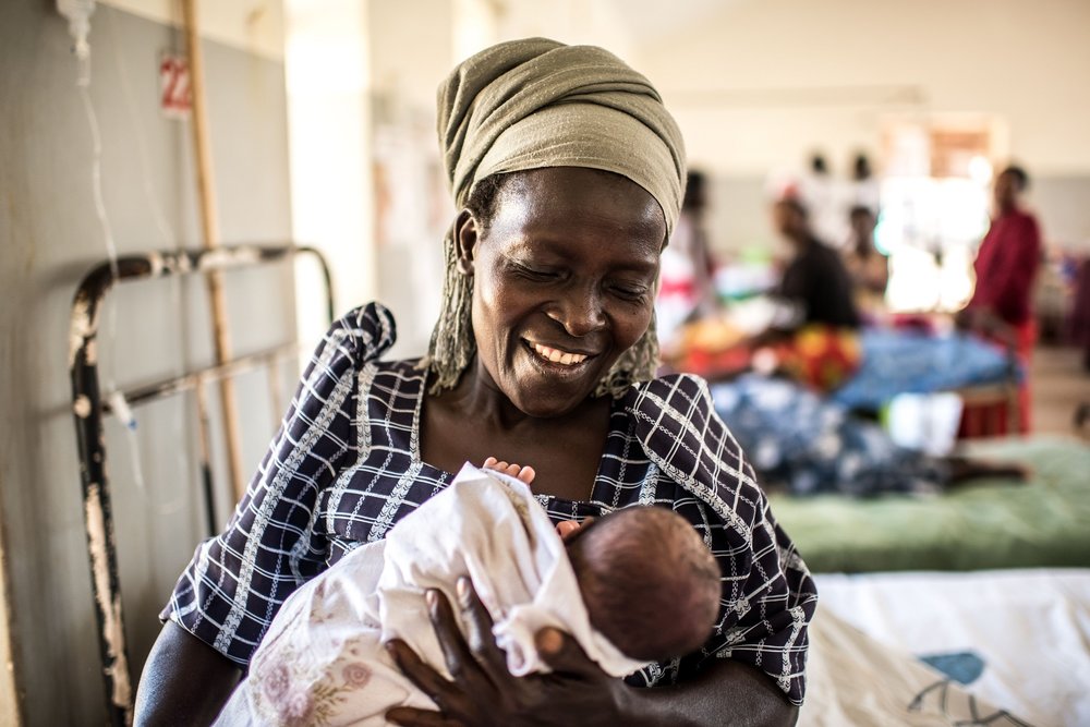  Dioweri Kalikumadi smiles as she holds her one-day old granddaughter in the maternity ward of the Jinja Regional Referral Hospital. 
