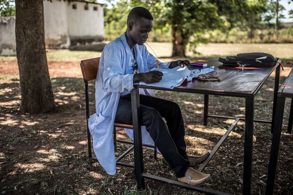  Students of the Soroti Pharmacy Schoolrelax and revise in the shade of a tree. 