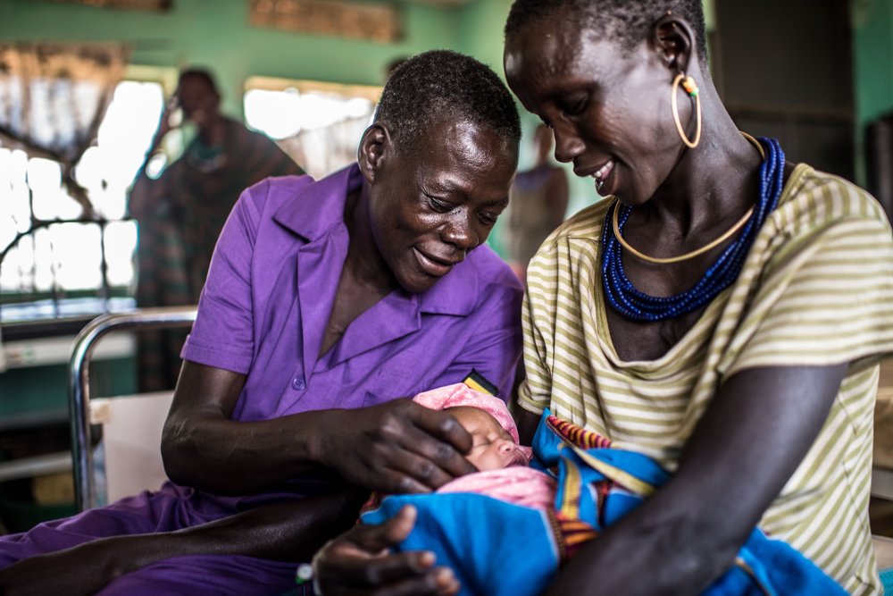  Najore Ruth, 45, a nursing assistant, sits with Angolere Lucy, who had her fifth baby overnight in the maternity ward of the Nadunget Health Center 3 in Karamoja, Uganda. 