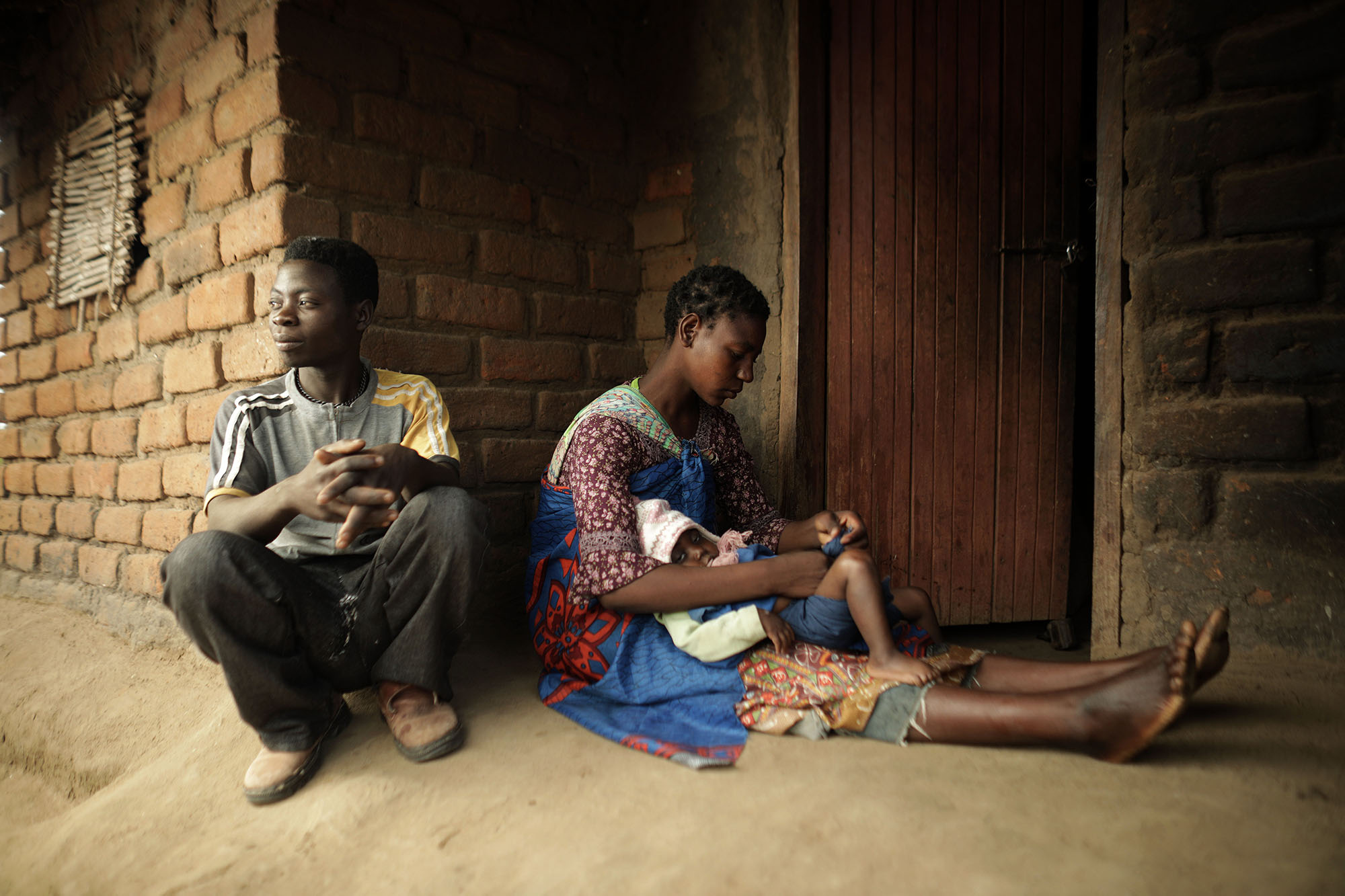  Mariam Chinguwo holds her daughter, Maness, while her husband, Hastings Sandikonda, looks on. 