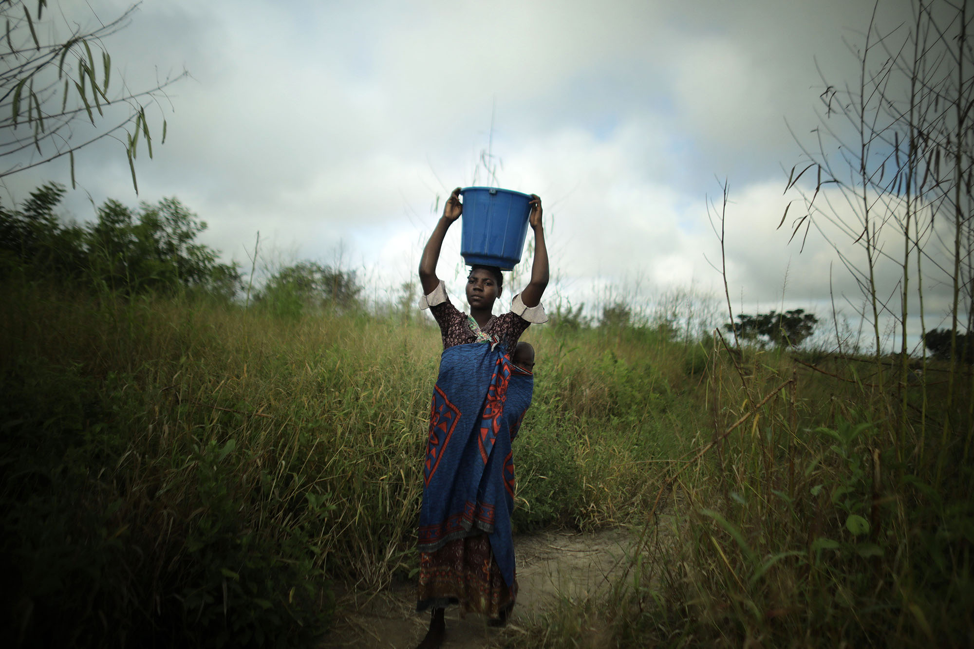  Mariam Chinguwo brings water back to her house. Photo by Josh Estey.&nbsp; 