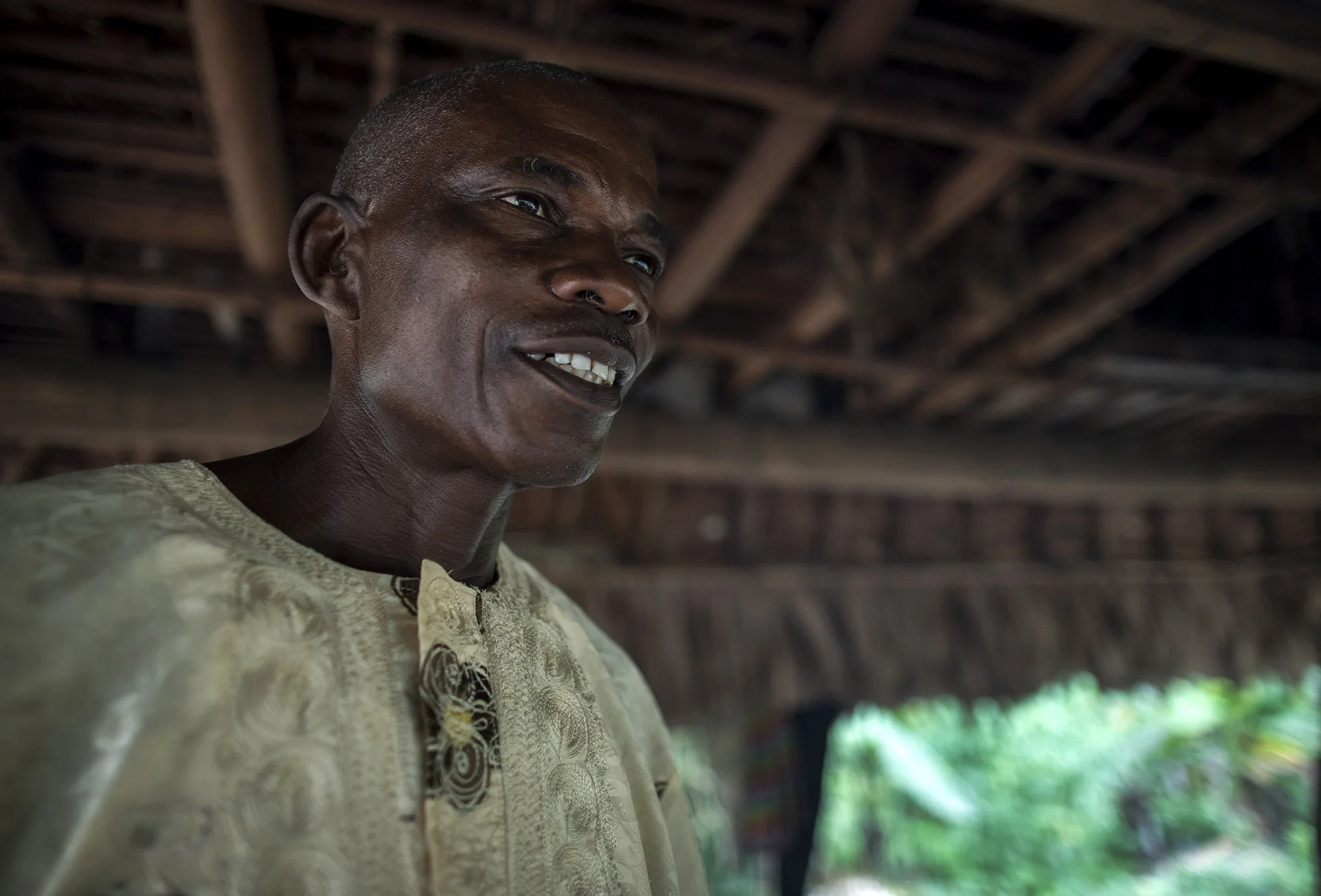 Garmondah Banwon, an elder in the Jogbahn Clan, stands in his kitchen in Blayah Town. The Jogbahn Clan fought against the British-owned company Equatorial Palm Oil (EPO) when they tried to take over their land in 2013. The people in the community depend on the land for their livelihoods. The Sustainable Development Institute (SDI) started to help the community by submitting a formal complaint to the to the Roundtable on Sustainable Palm Oil (RSPO). SDI taught the clan about land rights and resisting with non-violence. THE RSPO determined that the land EPO was using belonged to the clan. SGI trained the community how to map their land and boundaries were created that EPO accepted not to cross. Photo by Sarah Grile.