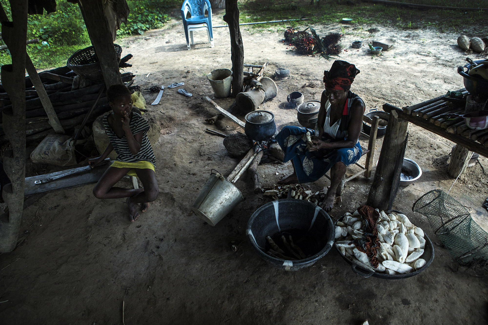  Sarah Banwon, right, the wife of Garmondah Banwon's, an elder in the Jogbahn Clan, prepares a meal in their kitchen in Blayah Town. The Jogbahn Clan fought against the British-owned company Equatorial Palm Oil (EPO) when they tried to take over thei