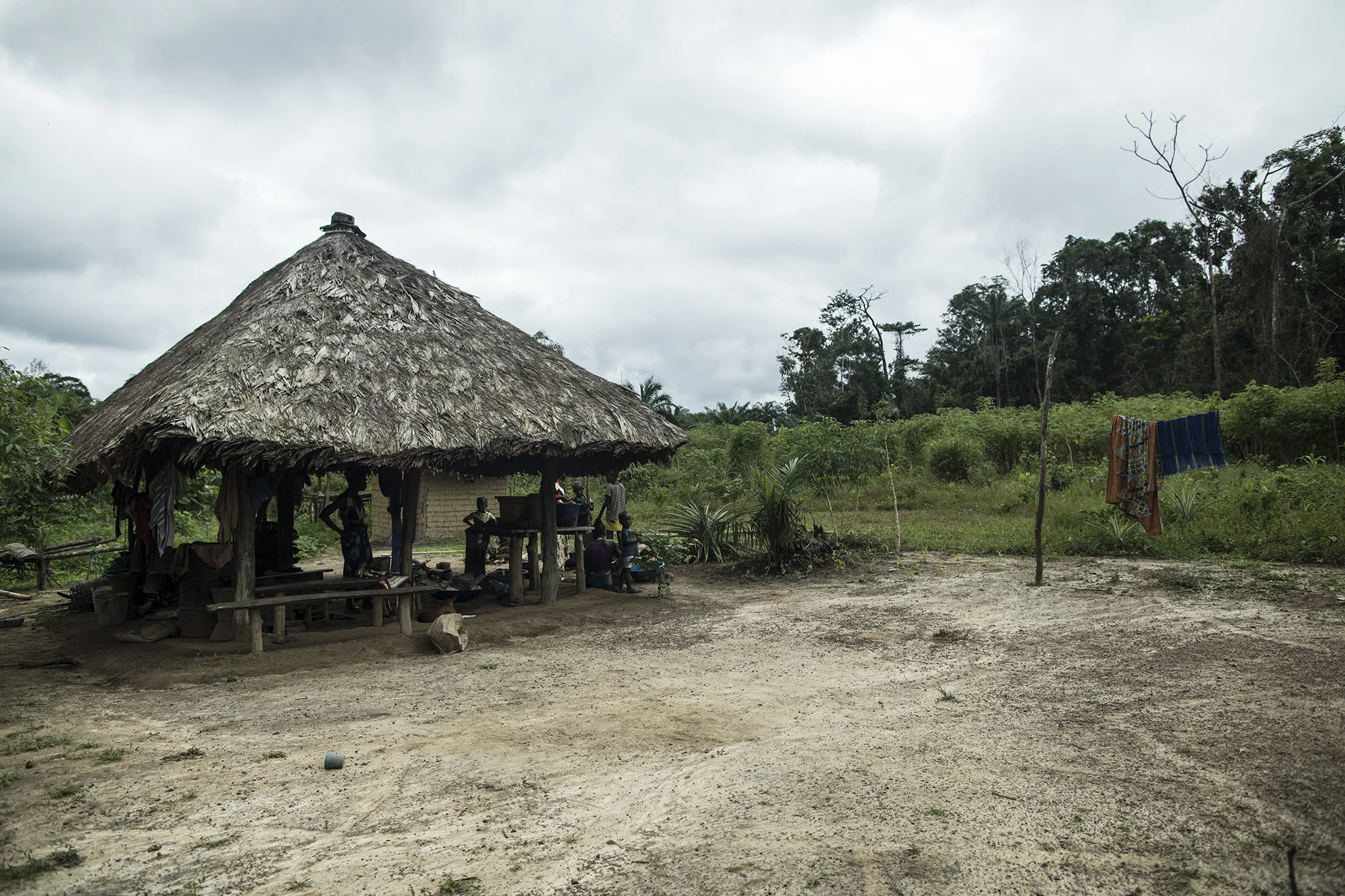 Sarah Banwon, right, the wife of Garmondah Banwon's, an elder in the Jogbahn Clan, prepares a meal in their kitchen in Blayah Town. The Jogbahn Clan fought against the British-owned company Equatorial Palm Oil (EPO) when they tried to take over their land in 2013. The people in the community depend on the land for their livelihoods. The Sustainable Development Institute (SDI) started to help the community by submitting a formal complaint to the to the Roundtable on Sustainable Palm Oil (RSPO). SDI taught the clan about land rights and resisting with non-violence. THE RSPO determined that the land EPO was using belonged to the clan. SGI trained the community how to map their land and boundaries were created that EPO accepted not to cross. Photo by Sarah Grile.