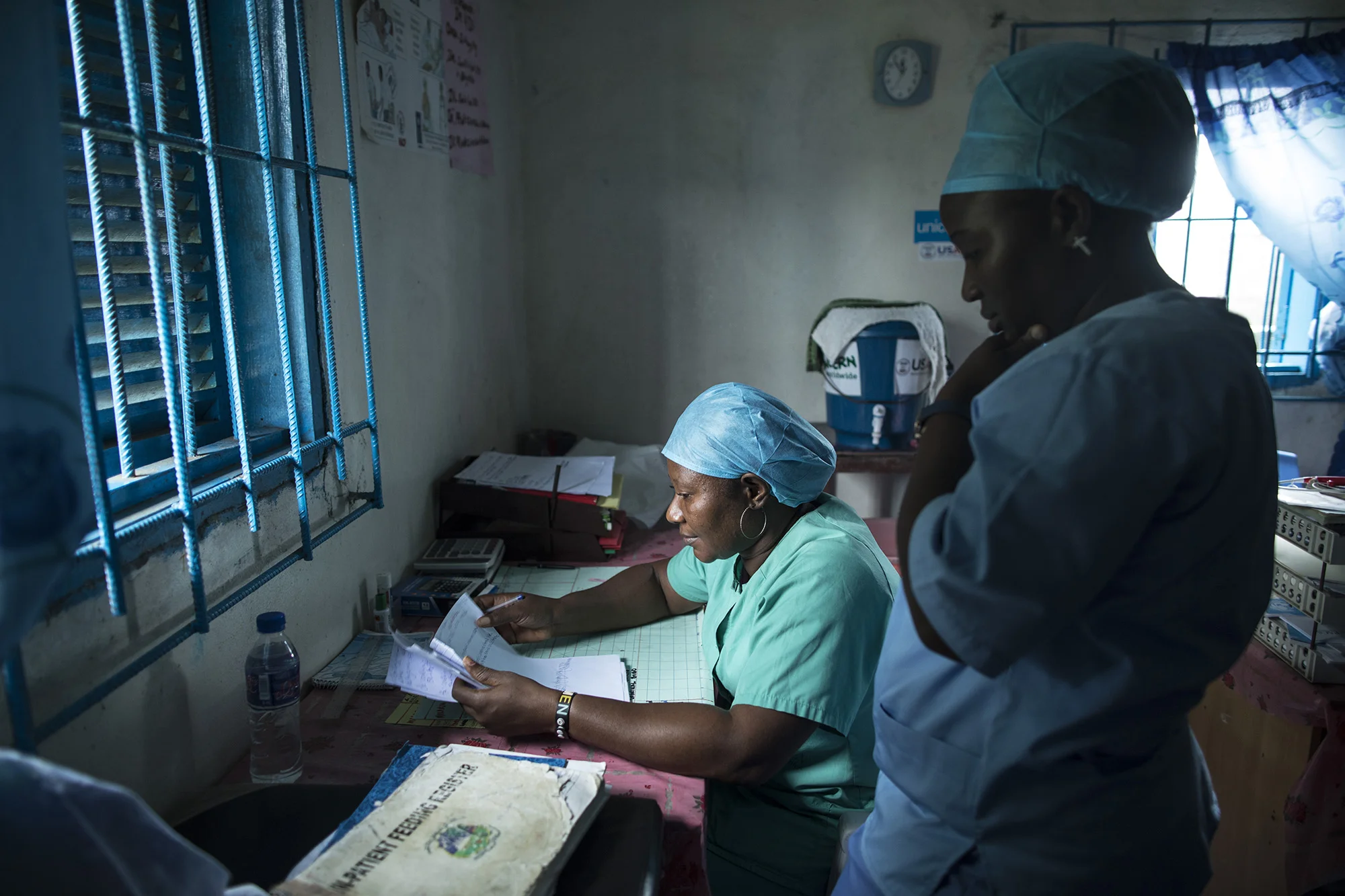 BREWERVILLE, LIBERIA: Aug. 22, 2017 - Wislyne S. Yarh Sieh is a registered nurse and Officer in Charge (OIC) at Kpallah Community Clinic in Brewerville. Wisylne worked as a healthcare worker during the Ebola outbreak in 2014-2015. Healthcare workers like Wislyne were left isolated and alone to fight this mysterious disease from the heart of the jungle. But, she, along with many others, continued to fight. "Being a nurse is like being a soldier. You cannot take your uniform off when there is battle. Then you are not a soldier. So I went on the frontline because I wanted to save lives," she remembers.
The Ministry of Health did not have a centralized system to communicate vital information to healthcare workers across the country at the same time. UNICEF and USAID worked together to create a platform that utilized mobile phones to facilitate a two way communications system between healthcare workers and the centralized ministry.
Because of this new technology, healthcare workers across the country can receive text messages with important information about health emergencies. They are also able to use their phones to inform the Ministry of Health about the status of stocks in the clinic.
Since Ebola, Wislyne has started using the new platform and now feels more connected and informed. She says, "If this program just stopped without things being in place, it would carry our work backward. It would make my work longer and delay treatment of the patients." Photo by Sarah Grile.
