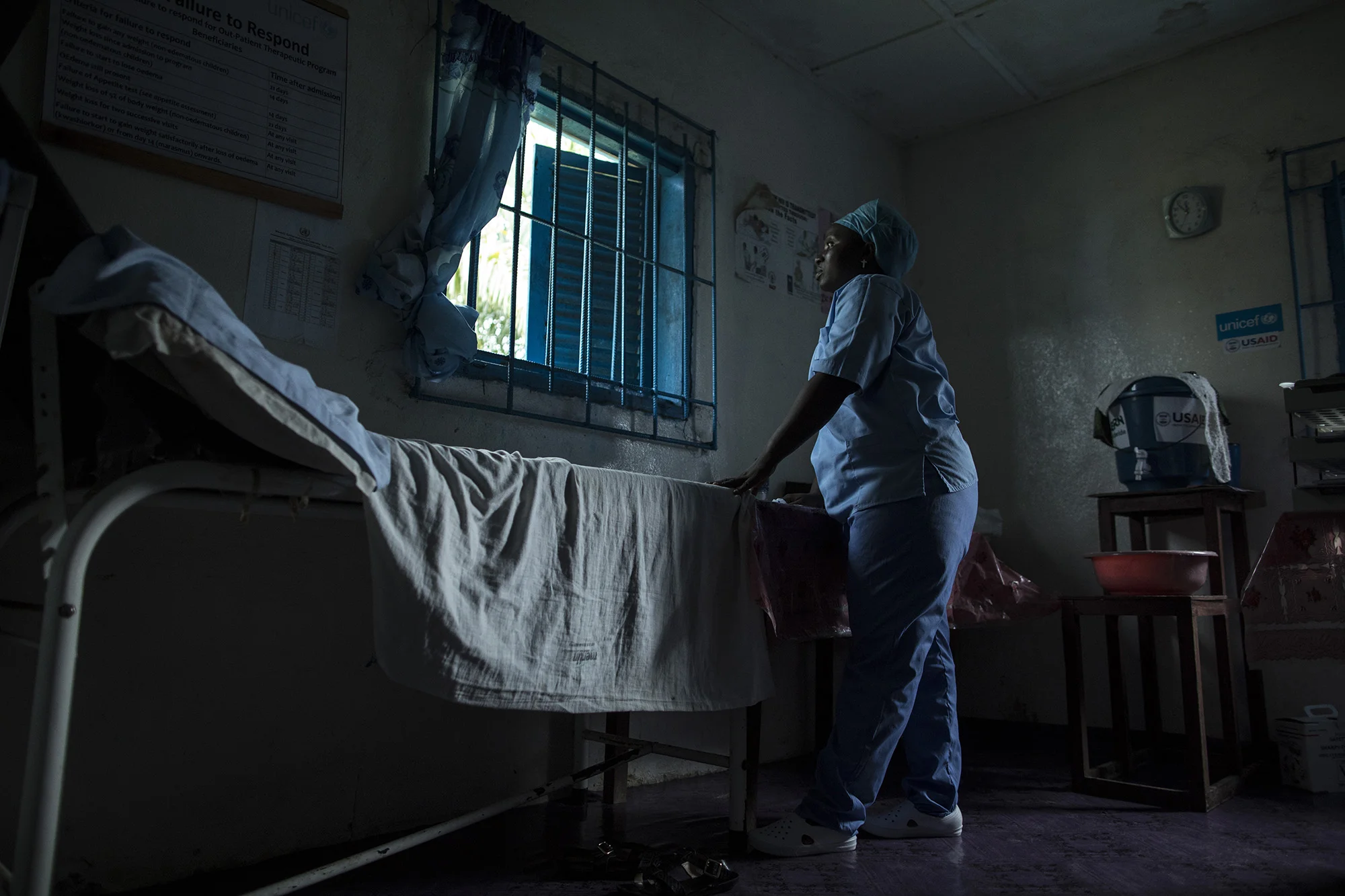 BREWERVILLE, LIBERIA: Aug. 22, 2017 - Wislyne S. Yarh Sieh is a registered nurse and Officer in Charge (OIC) at Kpallah Community Clinic in Brewerville. Wisylne worked as a healthcare worker during the Ebola outbreak in 2014-2015. Healthcare workers like Wislyne were left isolated and alone to fight this mysterious disease from the heart of the jungle. But, she, along with many others, continued to fight. "Being a nurse is like being a soldier. You cannot take your uniform off when there is battle. Then you are not a soldier. So I went on the frontline because I wanted to save lives," she remembers.
The Ministry of Health did not have a centralized system to communicate vital information to healthcare workers across the country at the same time. UNICEF and USAID worked together to create a platform that utilized mobile phones to facilitate a two way communications system between healthcare workers and the centralized ministry.
Because of this new technology, healthcare workers across the country can receive text messages with important information about health emergencies. They are also able to use their phones to inform the Ministry of Health about the status of stocks in the clinic.
Since Ebola, Wislyne has started using the new platform and now feels more connected and informed. She says, "If this program just stopped without things being in place, it would carry our work backward. It would make my work longer and delay treatment of the patients." Photo by Sarah Grile.