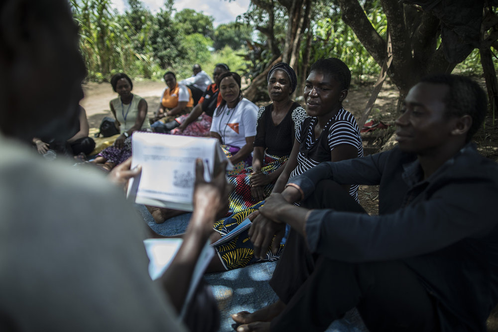  CHONGWE, ZAMBIA: Feb. 19, 2018 - Members of the CARE Learning Tour to Zambia delegation watch as Dennis Chulu, left, goes over a birth planning story with David Hachitamba, right, and his wife, Memory Hachitamba,&nbsp;second from right, during a SMA