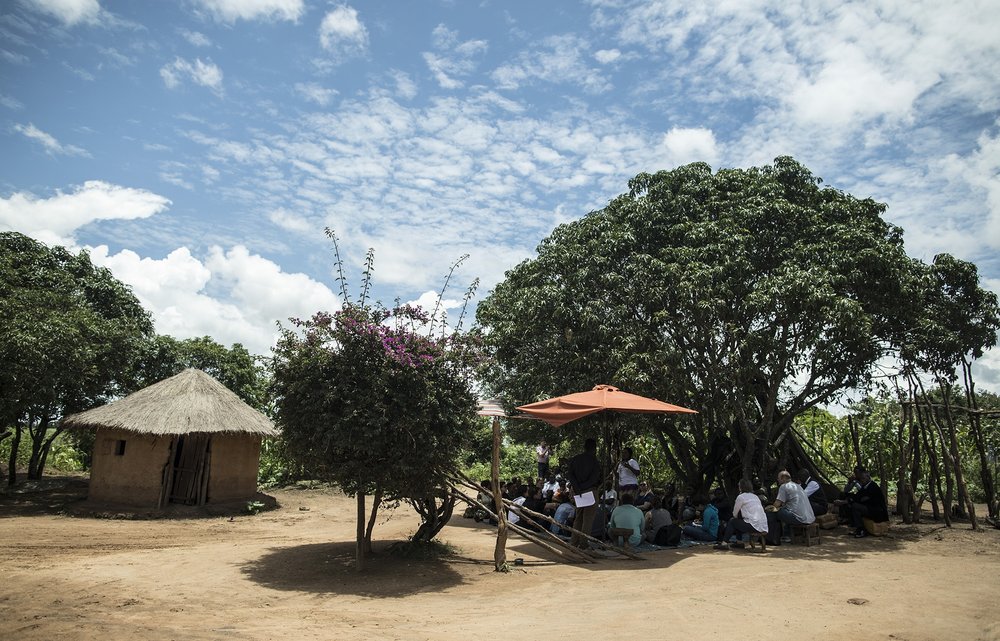  CHONGWE, ZAMBIA: Feb. 19, 2018 - Members of the CARE Learning Tour to Zambia delegation sit near the home of Memory Hachitamba while watching her participate in a SMAG home visit simulation about birth planning near the Kotaba Health Facility in Cho