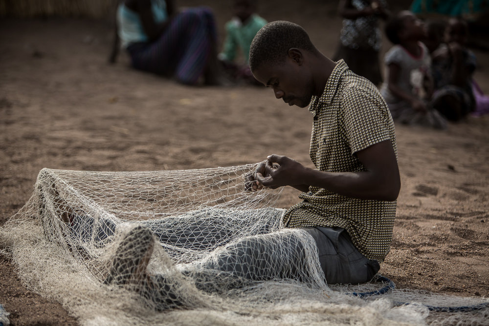 Jacob Rajah inspecting and repairing fishing nets