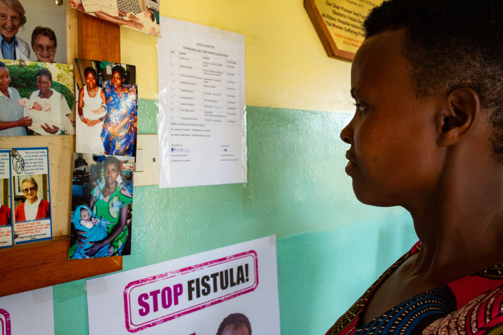  MASAKA DISTRICT, UGANDA: March 28, 2019  - Fistula survivor Justine Nitele looks at an old photo of herself from when she delivered her child at Kitovu Mission Hospital.  She also had her fistula repair surgery performed at this hospital.
Photo by: 