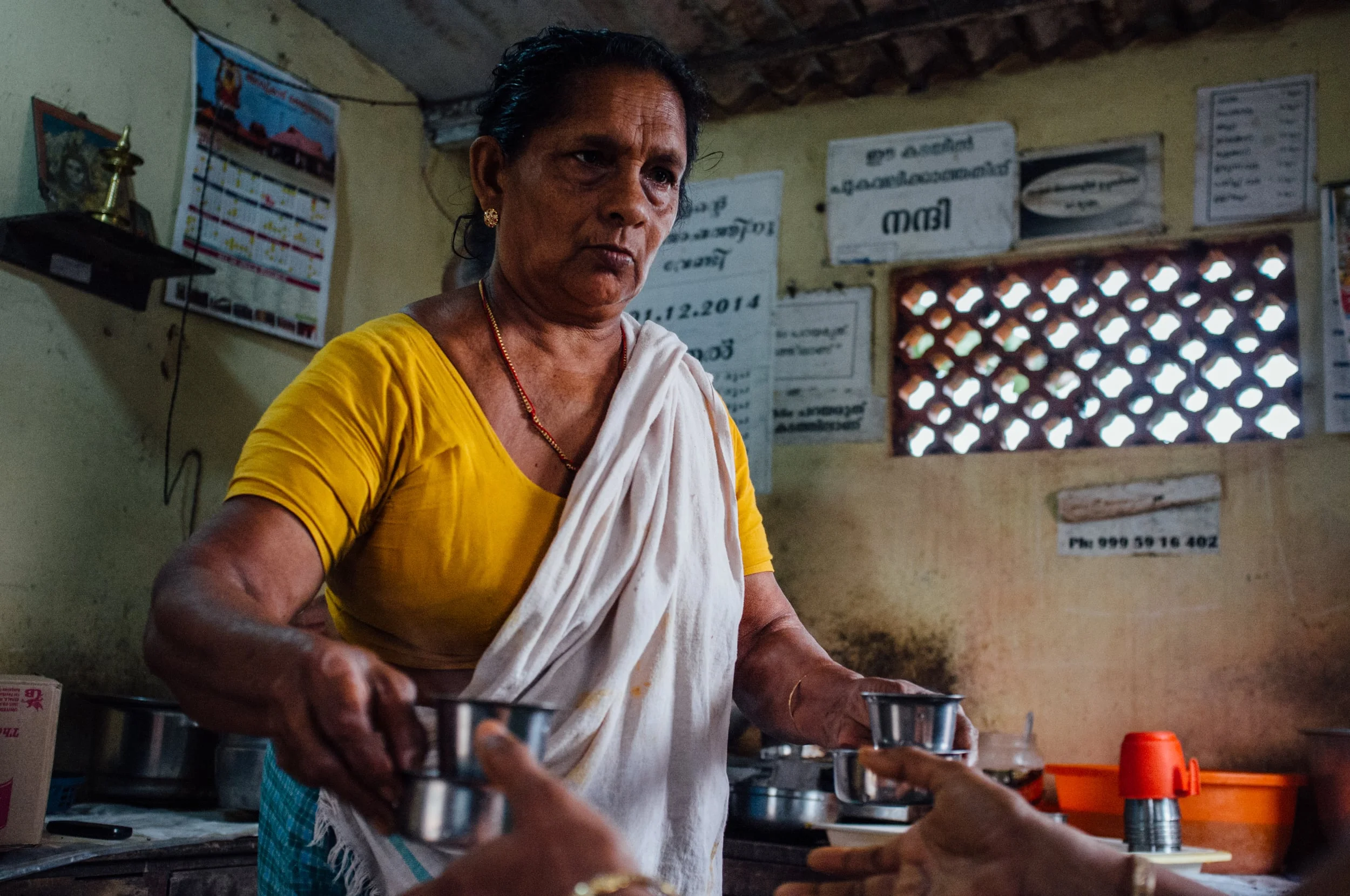 Woman serving tea at a thattukada (typically, a roadside eatery) in Pallathuruthy, Kuttanad, Kerala