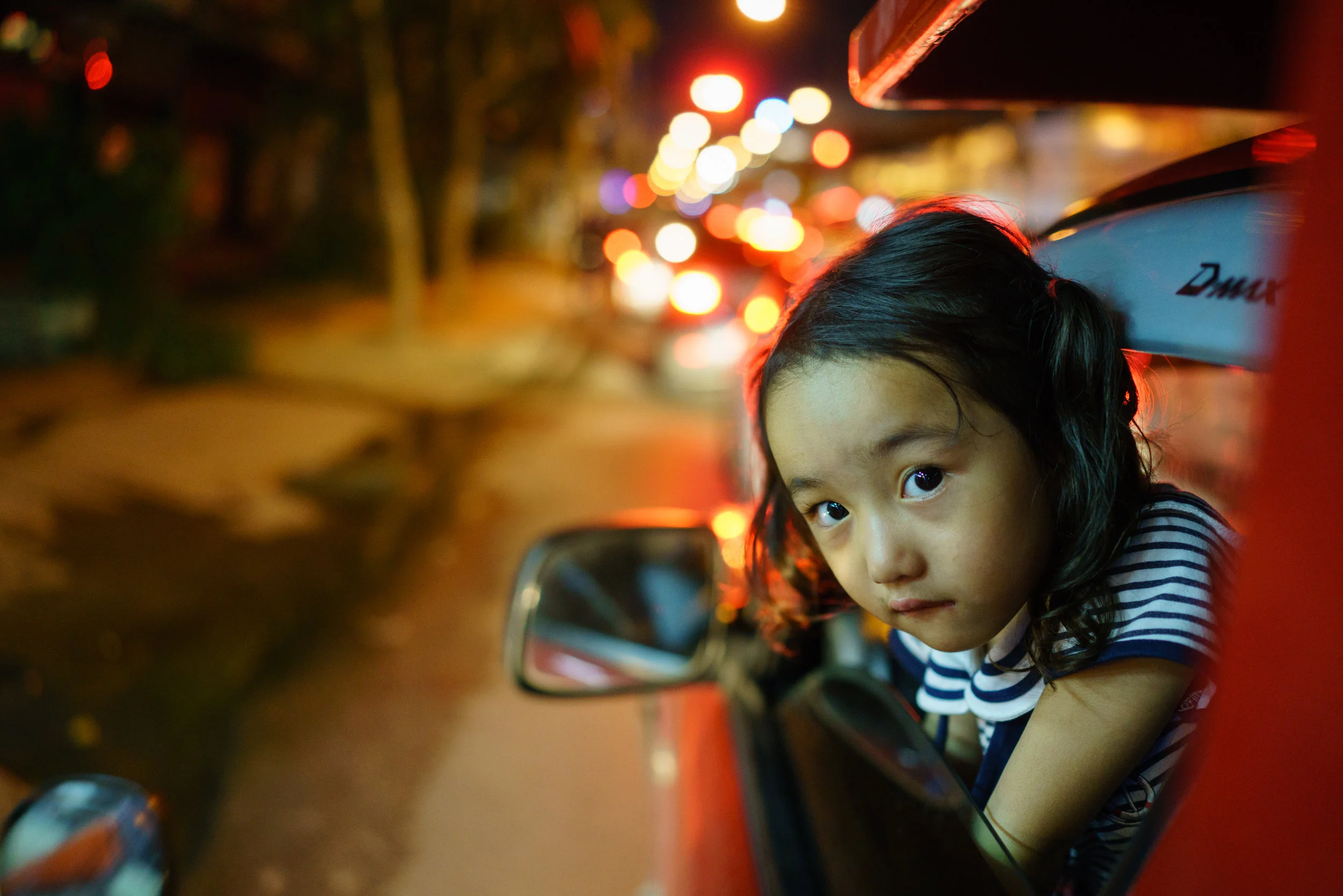 Often you'll find families of the songthaew driver sitting up front; here a young girl plays peekaboo with Prem from the front seat