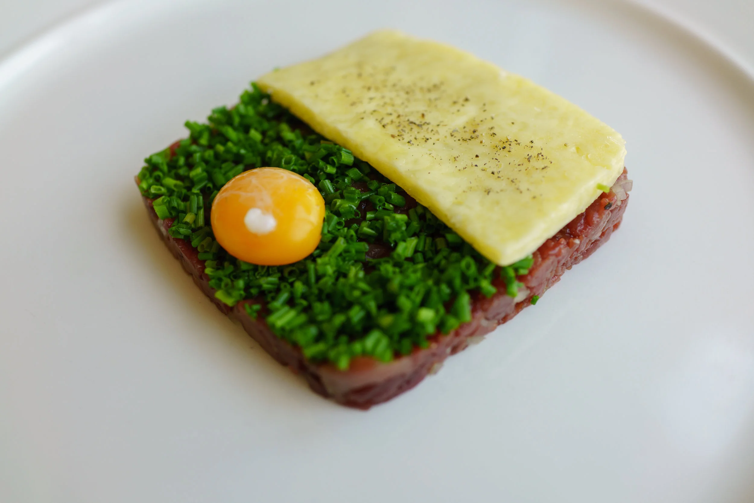 Venison tartare, fleur de sel butter, poached quail egg yolk, chives at Bistro Apetit