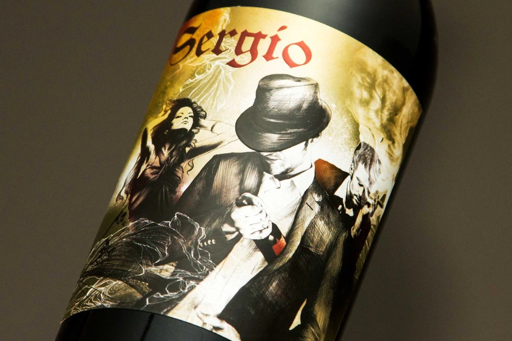 A wine bottle label featuring black and white illustrations of a man with a hat, a woman with long hair, and a man with a beard, surrounded by flames and abstract designs, with the name 'Sergio' at the top.