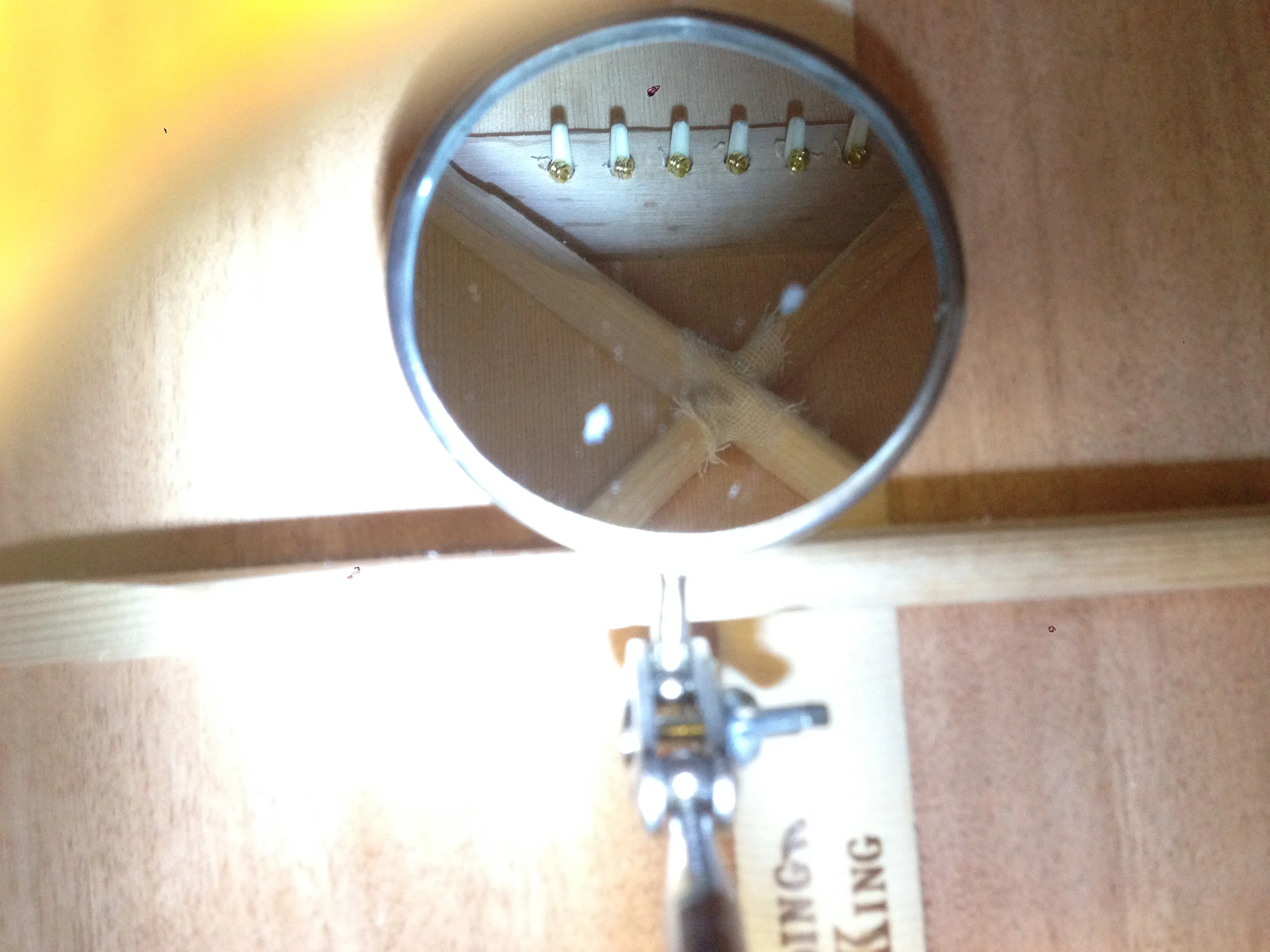 String Balls Against Bridge Pad Inside Guitar Body