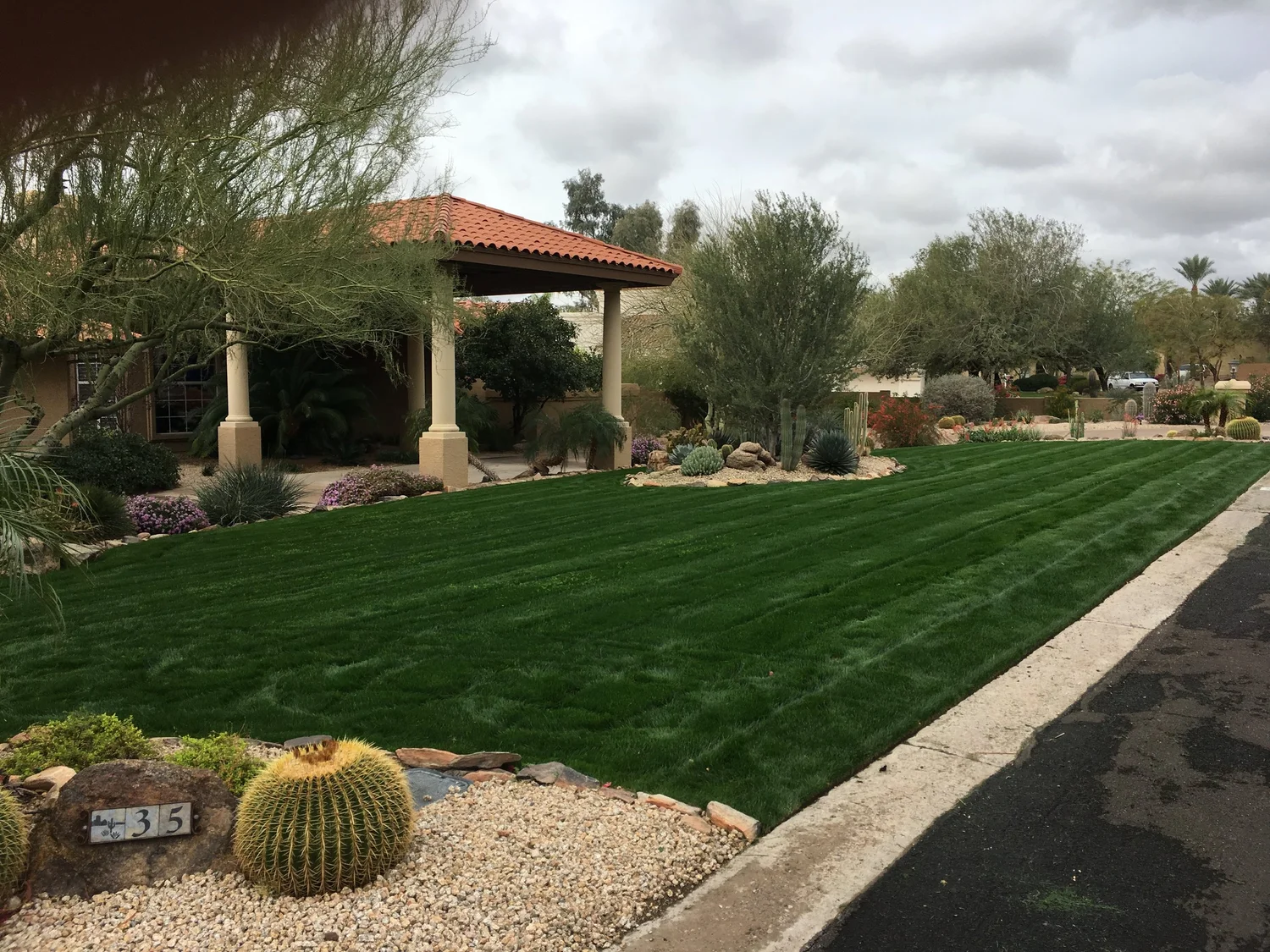 Fertilizer being applied to lawn and planting beds by Blooming Valley Landscape