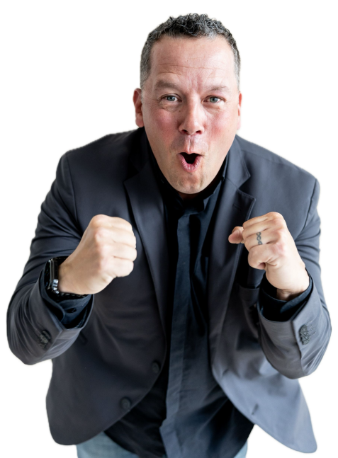 Tony Miltenberger in a dark blazer and black shirt showing excitement with clenched fists and an open mouth.
