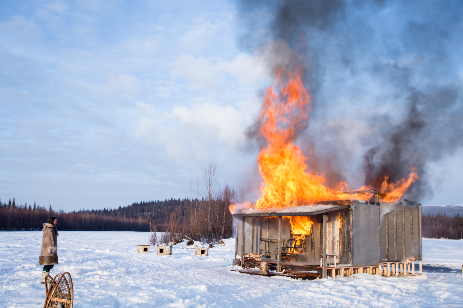 Atka looks on as his home burns to the ground. 