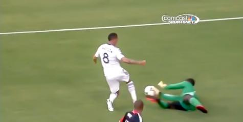 DC United's Bill Hamid wins the ball, but Vancouver Whitecaps FC's Matt Watson wins the penalty kick at RFK Stadium on 29 June 2013.