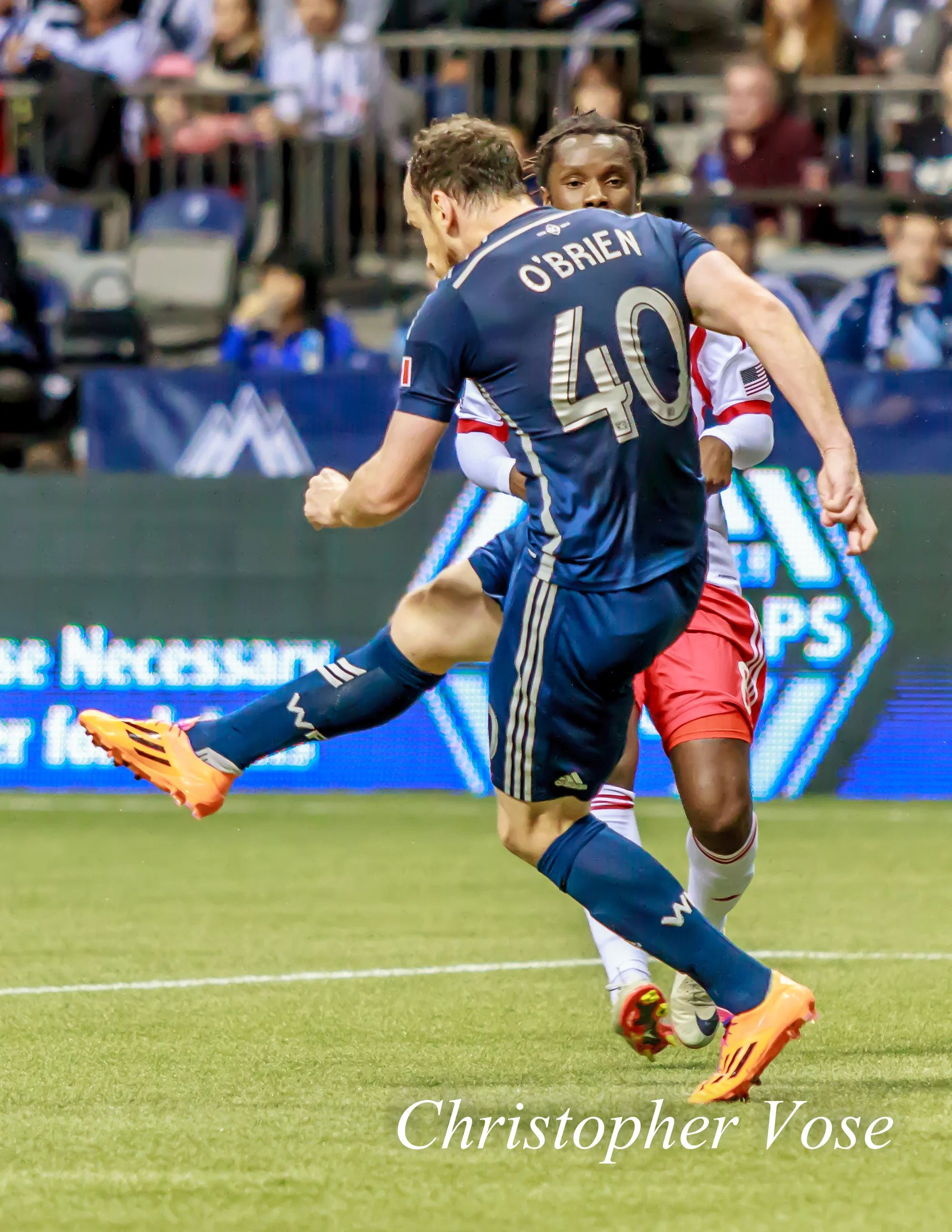 Andy O'Brien clears the ball from danger as Peguy Luyindula looks on at BC Place on 8 March 2014.