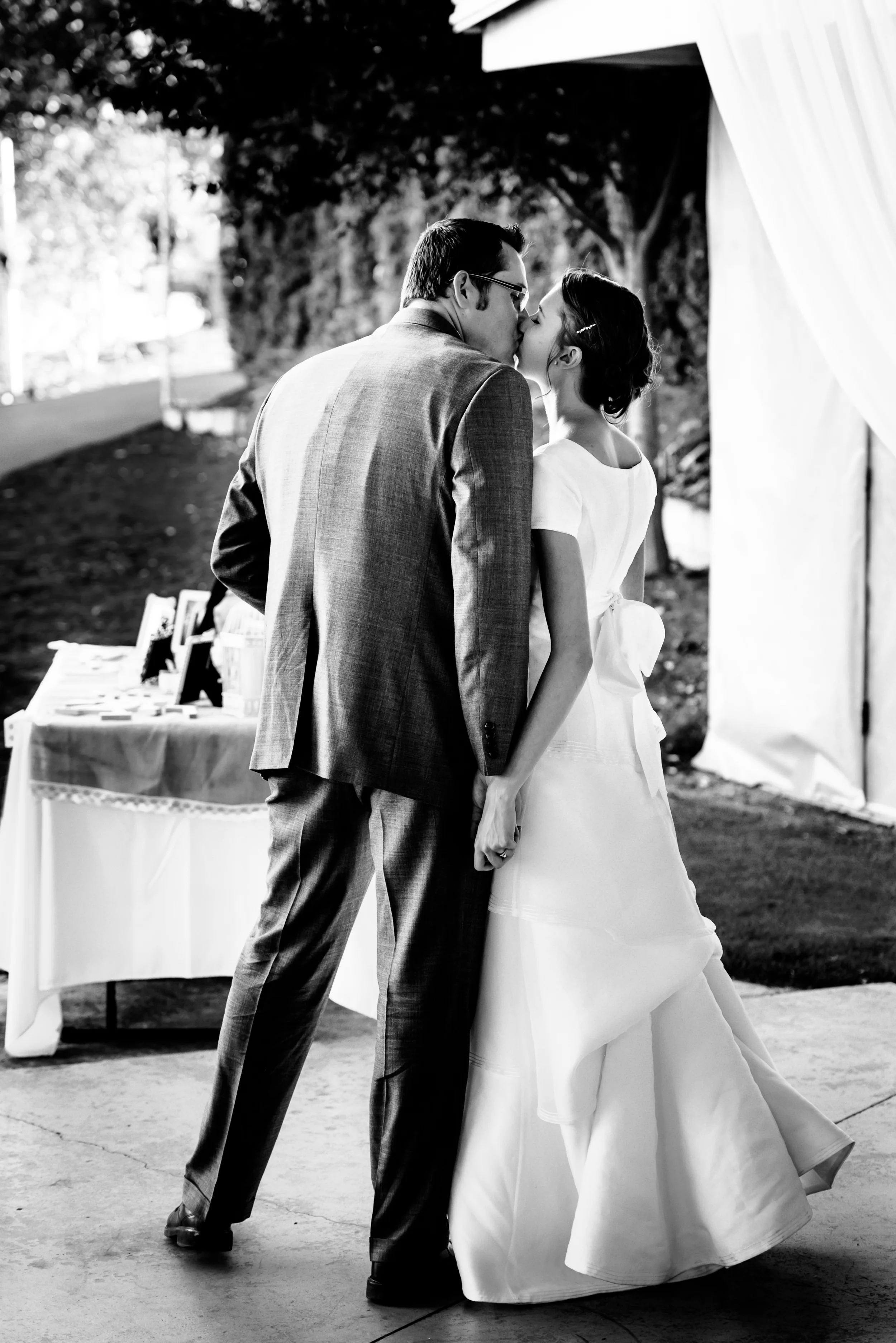 The bride and groom steal a kiss before the reception gets into full swing.