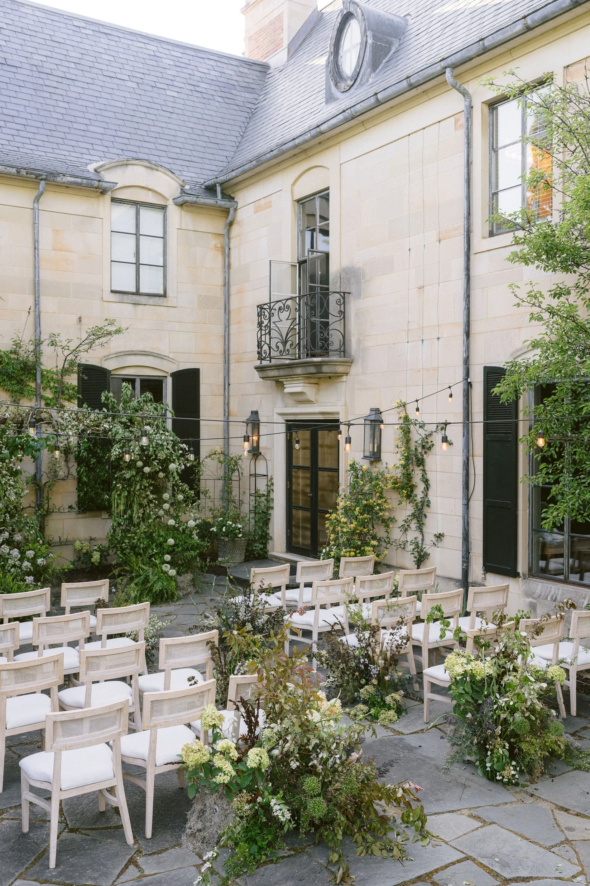 ceremony with lush organic florals set up on the back terrace of greencrest manor