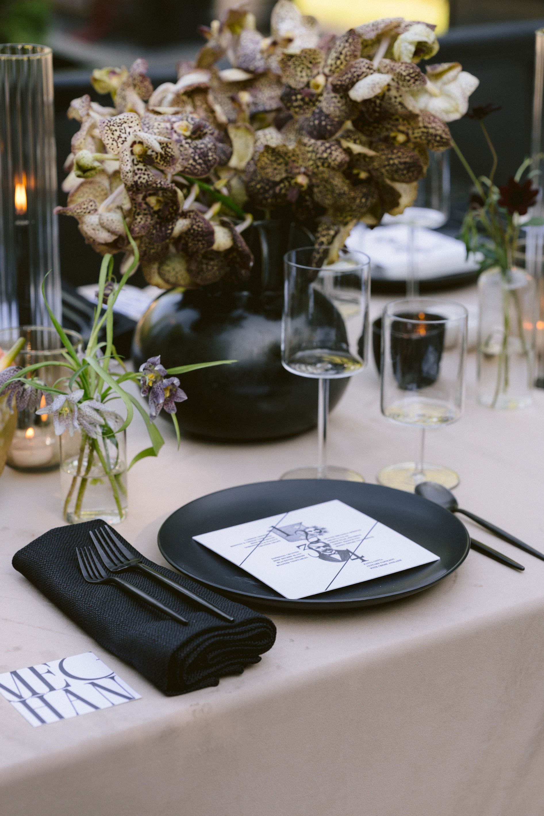 modern and romantic place setting with orchids in the background for wedding reception