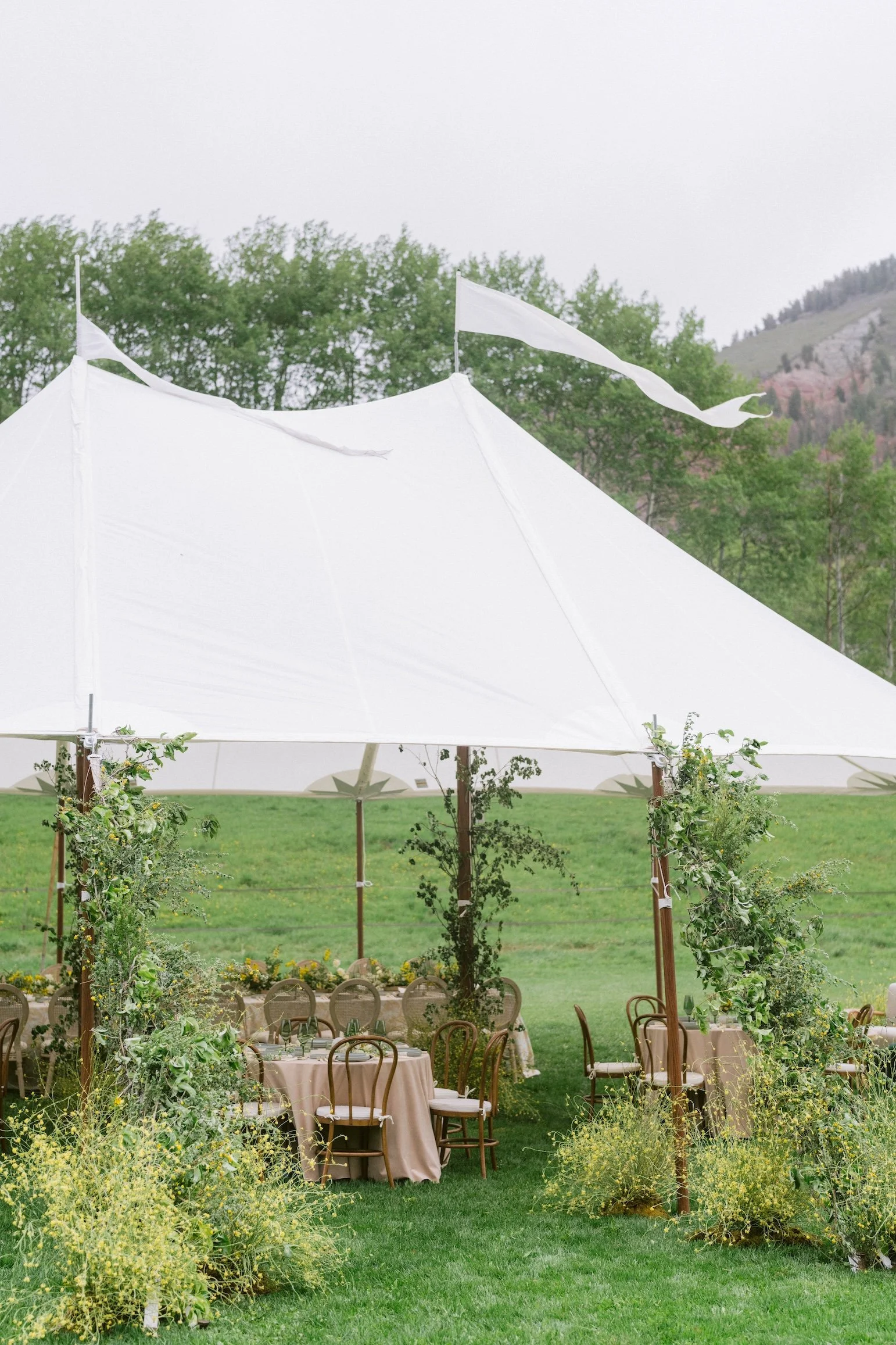 A sailcloth tent set up for a wedding reception in the meadow at T Lazy 7 Ranch in Aspen