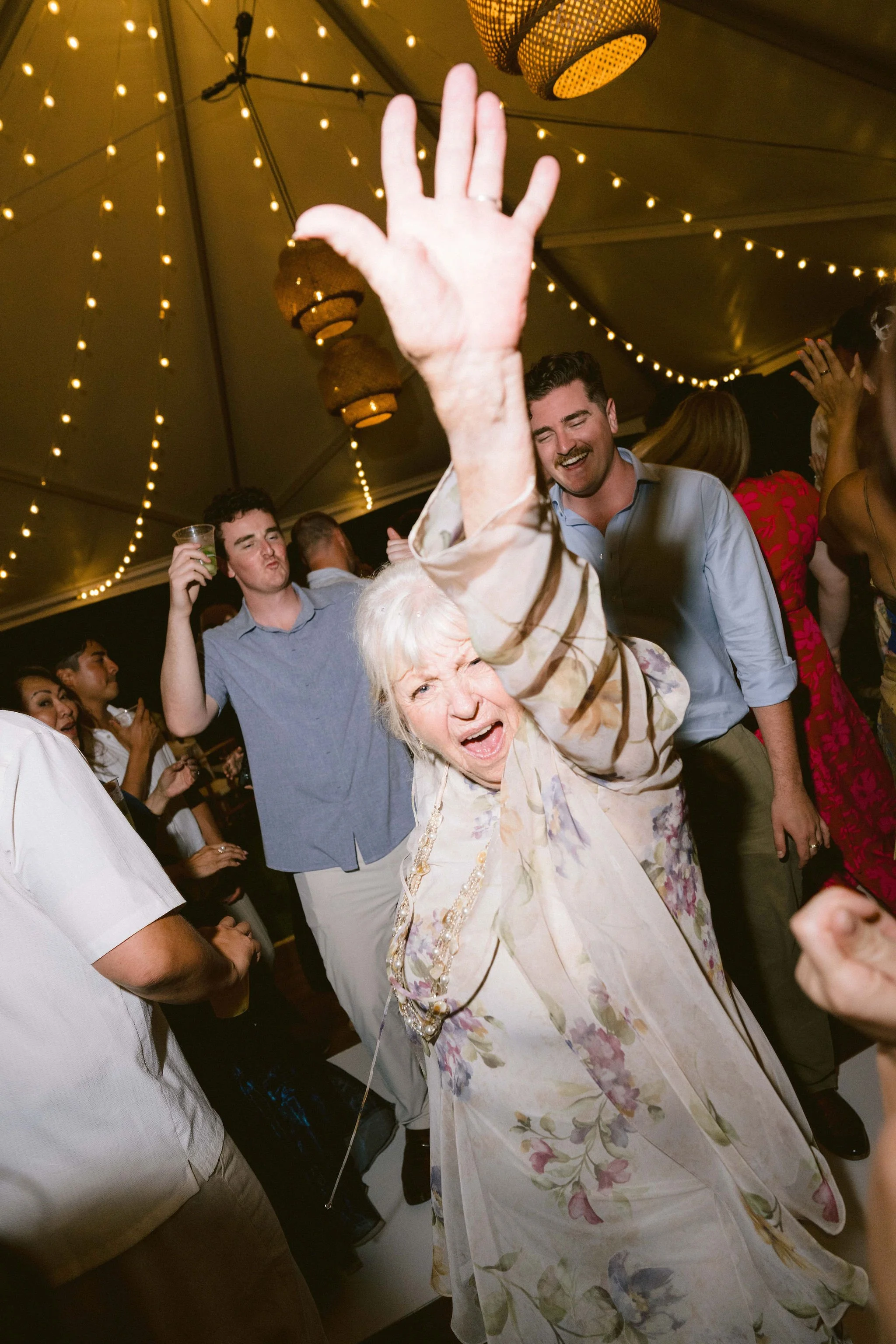 grandma cutting loose on the dance floor to a live band at kualoa ranch wedding reception