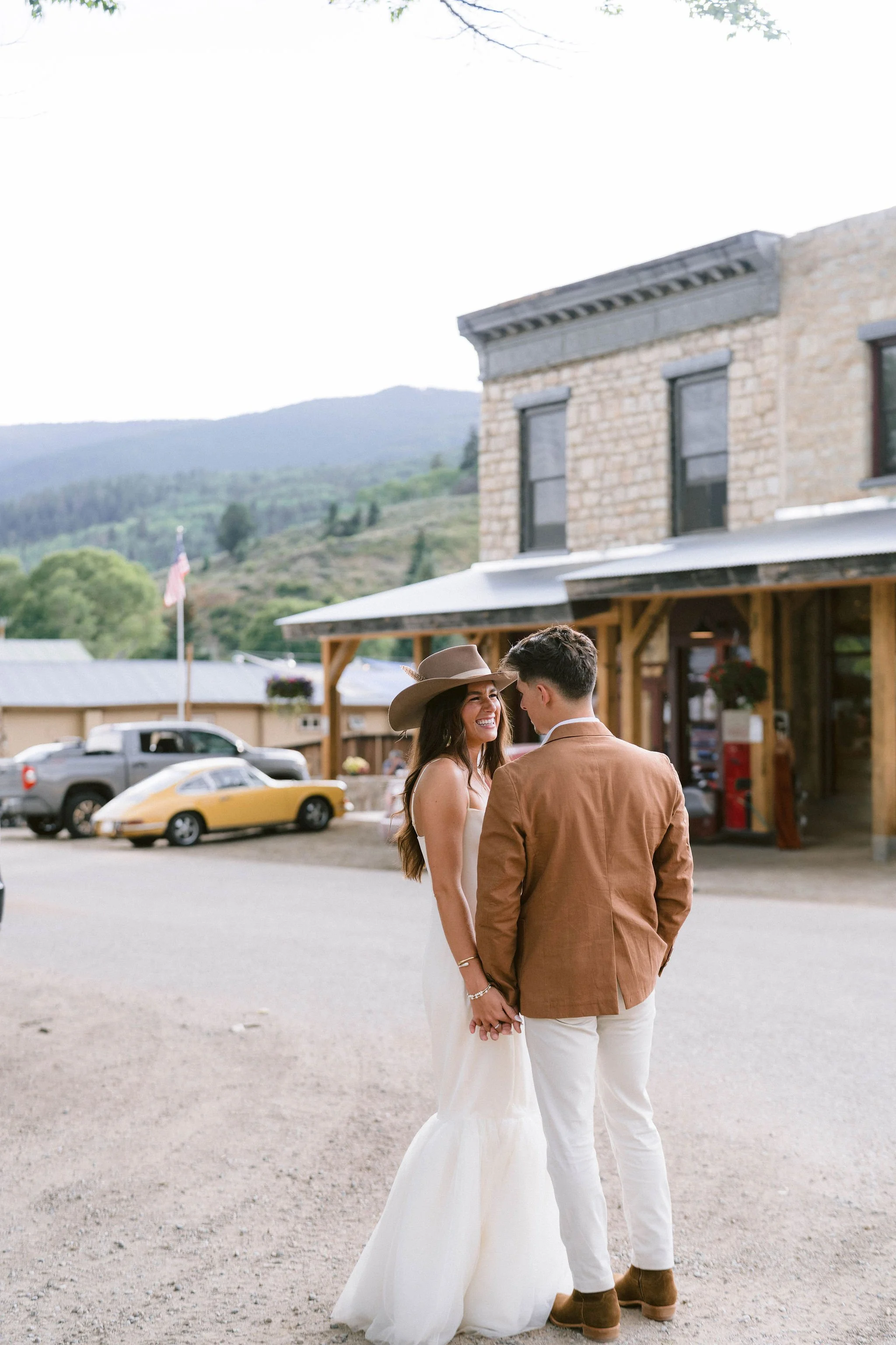 bride and groom smile at each other in front of the pitkin hotel