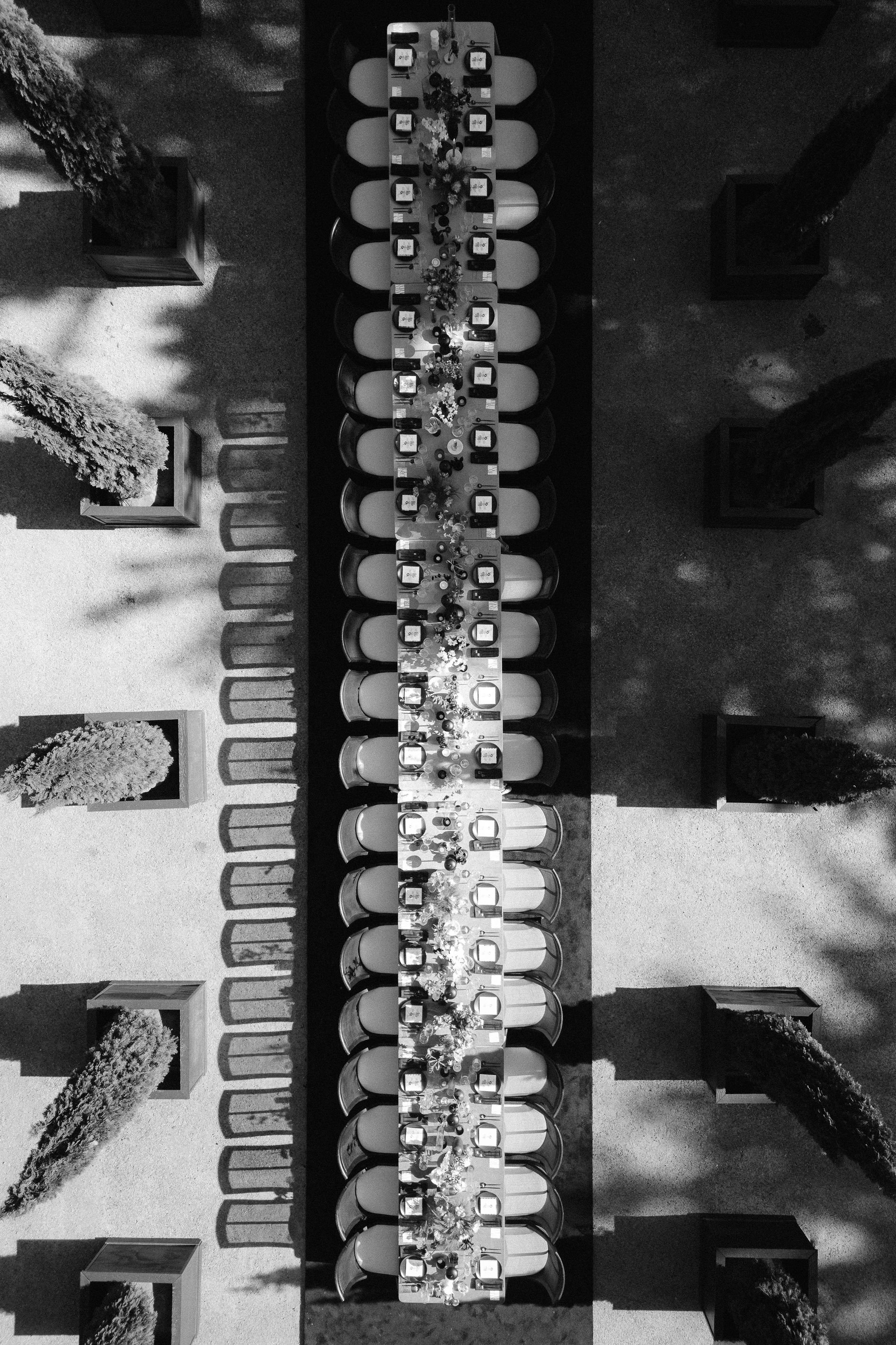 drone photo shooting overhead of a tablescape for a long reception table in the front of greencrest manor