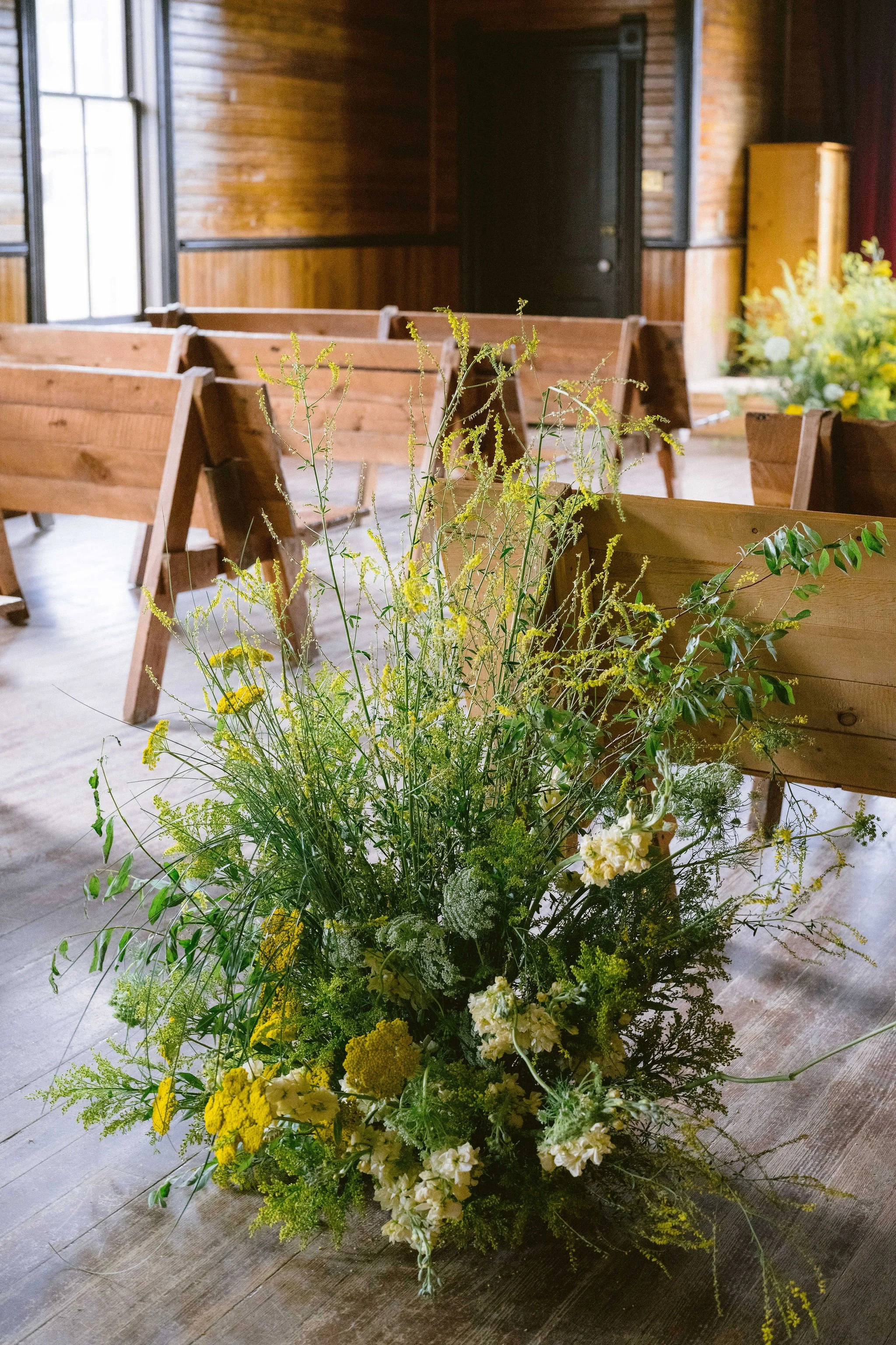 yellow wildflower floral aisle inside the chapel in tin cup