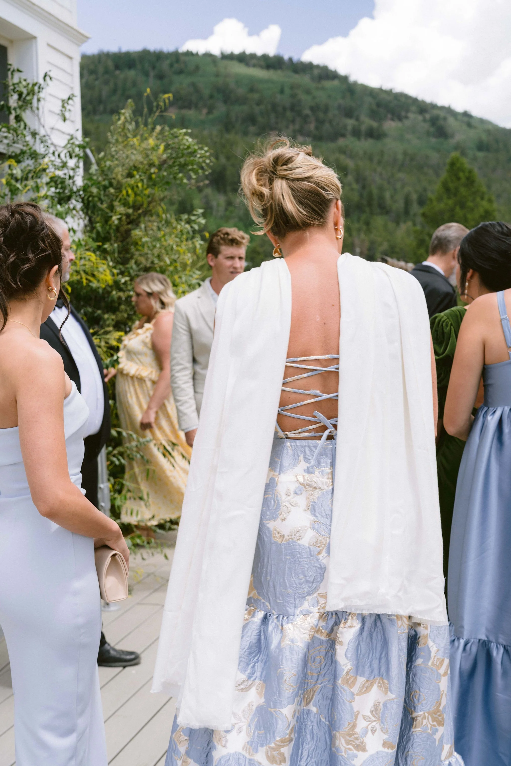 guests attend the wedding in shades of blue and green dresses