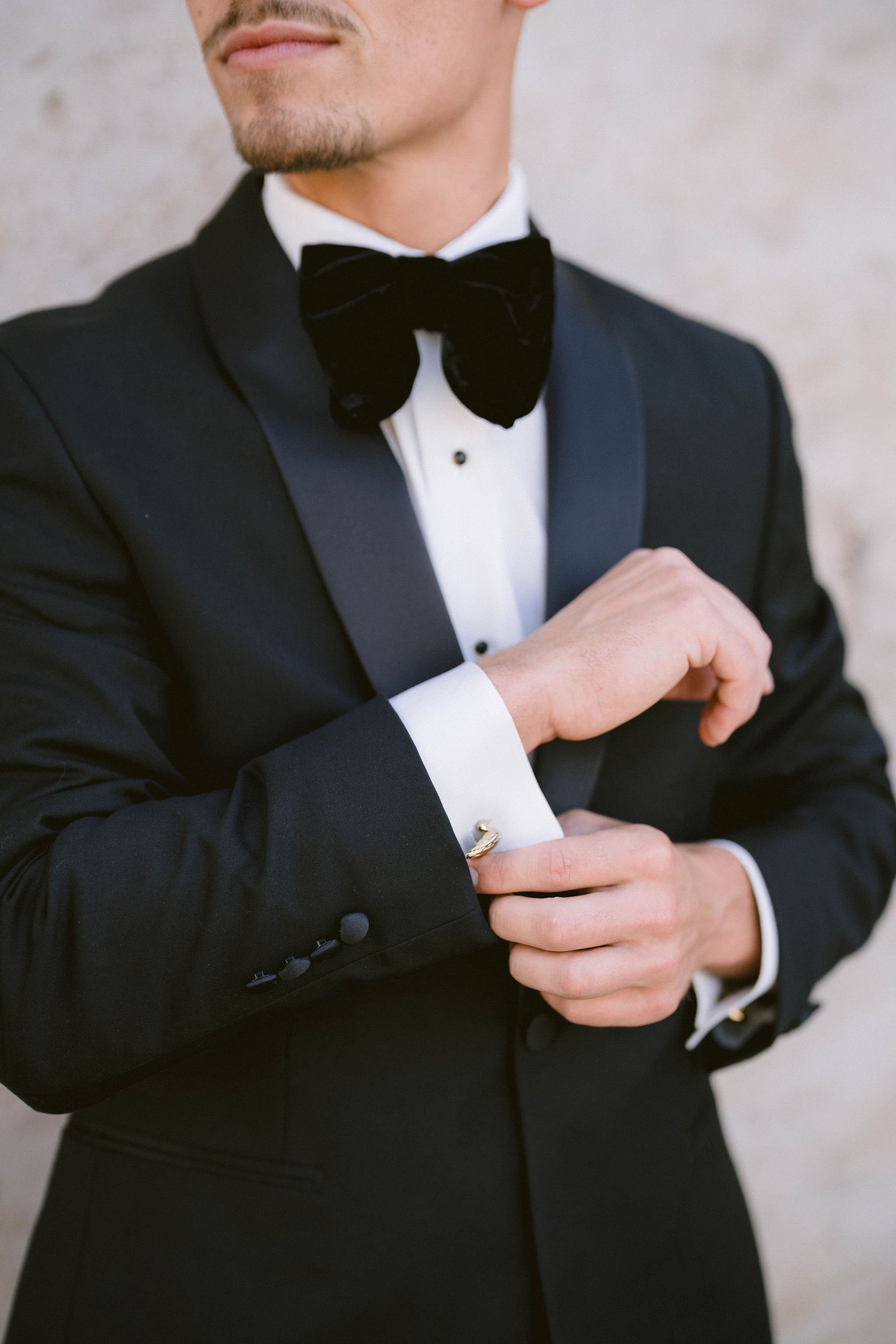 groom adjust his custom duck cuff links as he gets ready for wedding day
