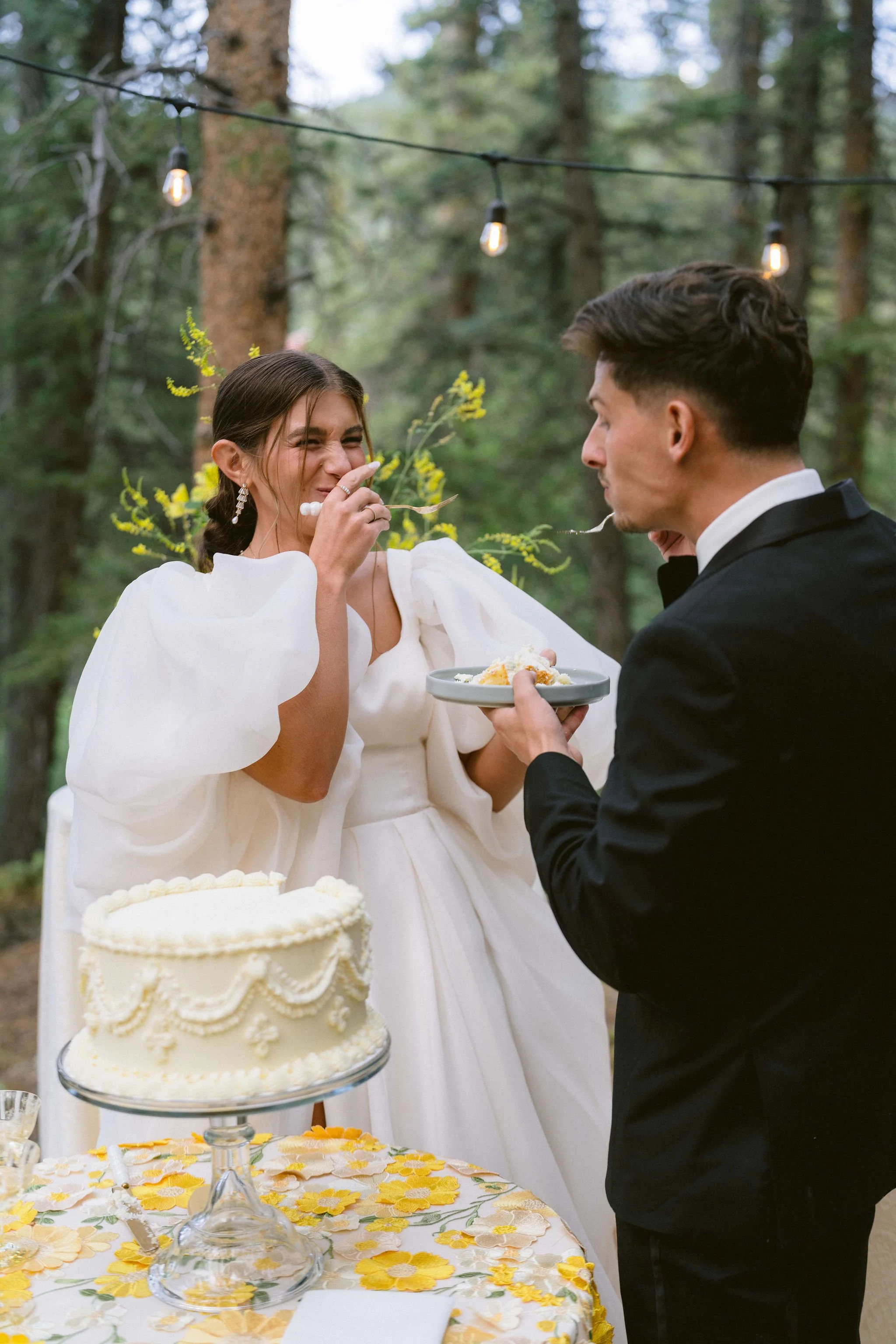 bride and groom feeding each other wedding cake at their reception