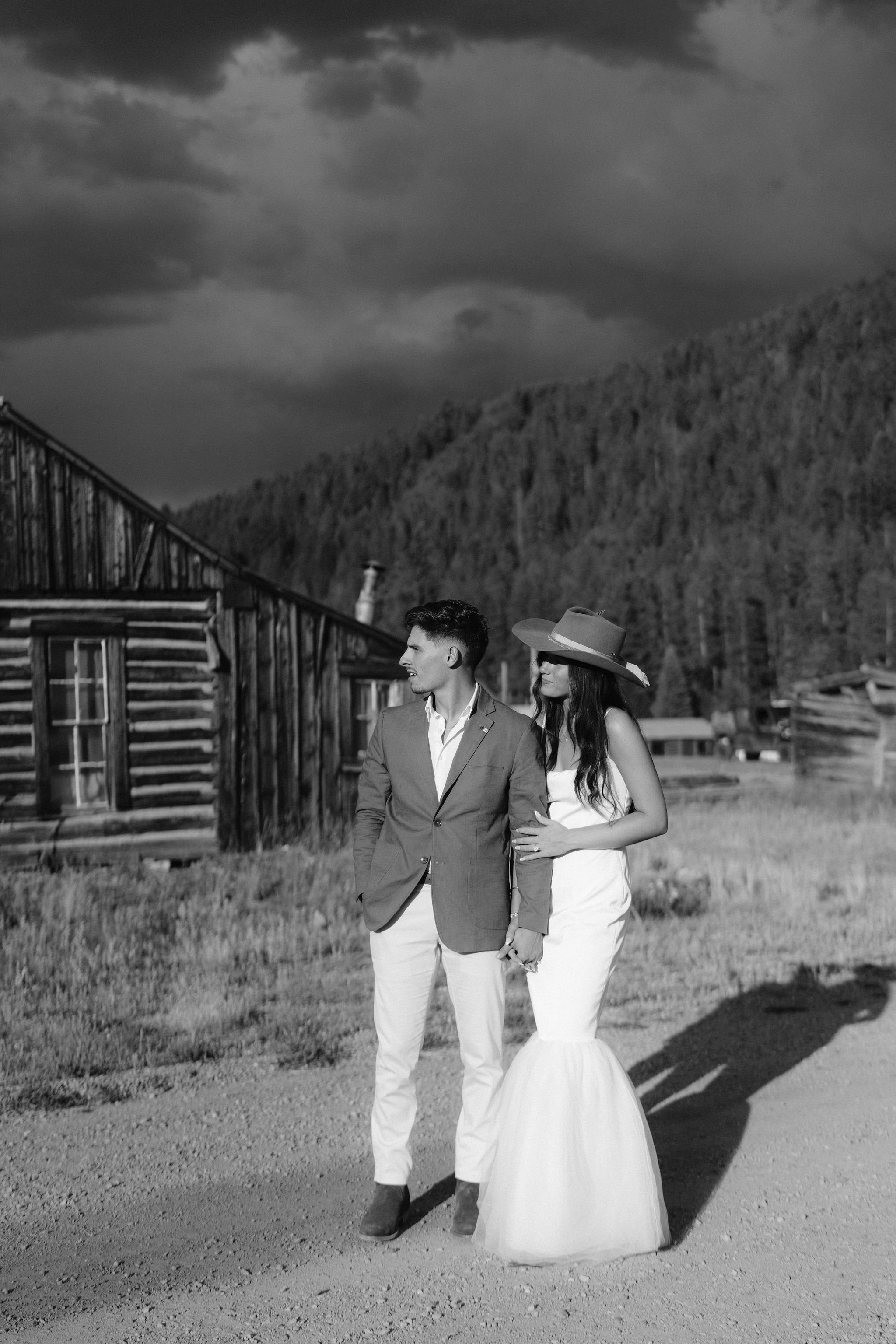bride and groom walk the mountain roads after their wedding welcome party in pitkin colorado