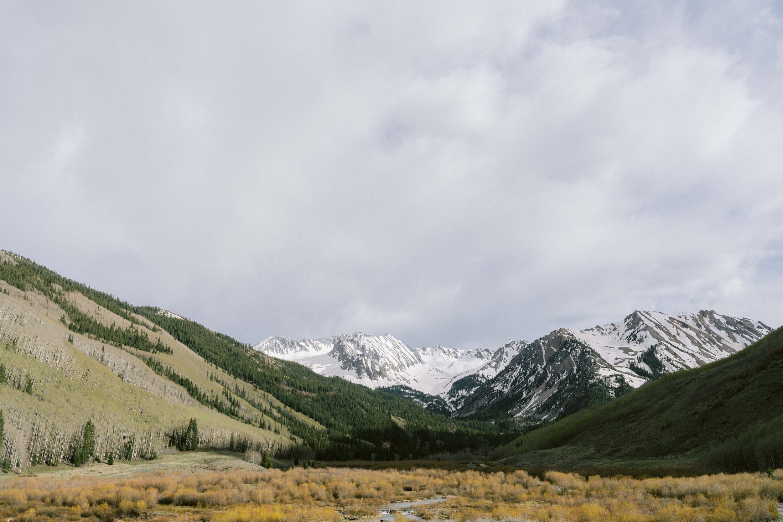 landscape photo of Aspen mountain valley with snow still on some of the moutaintops