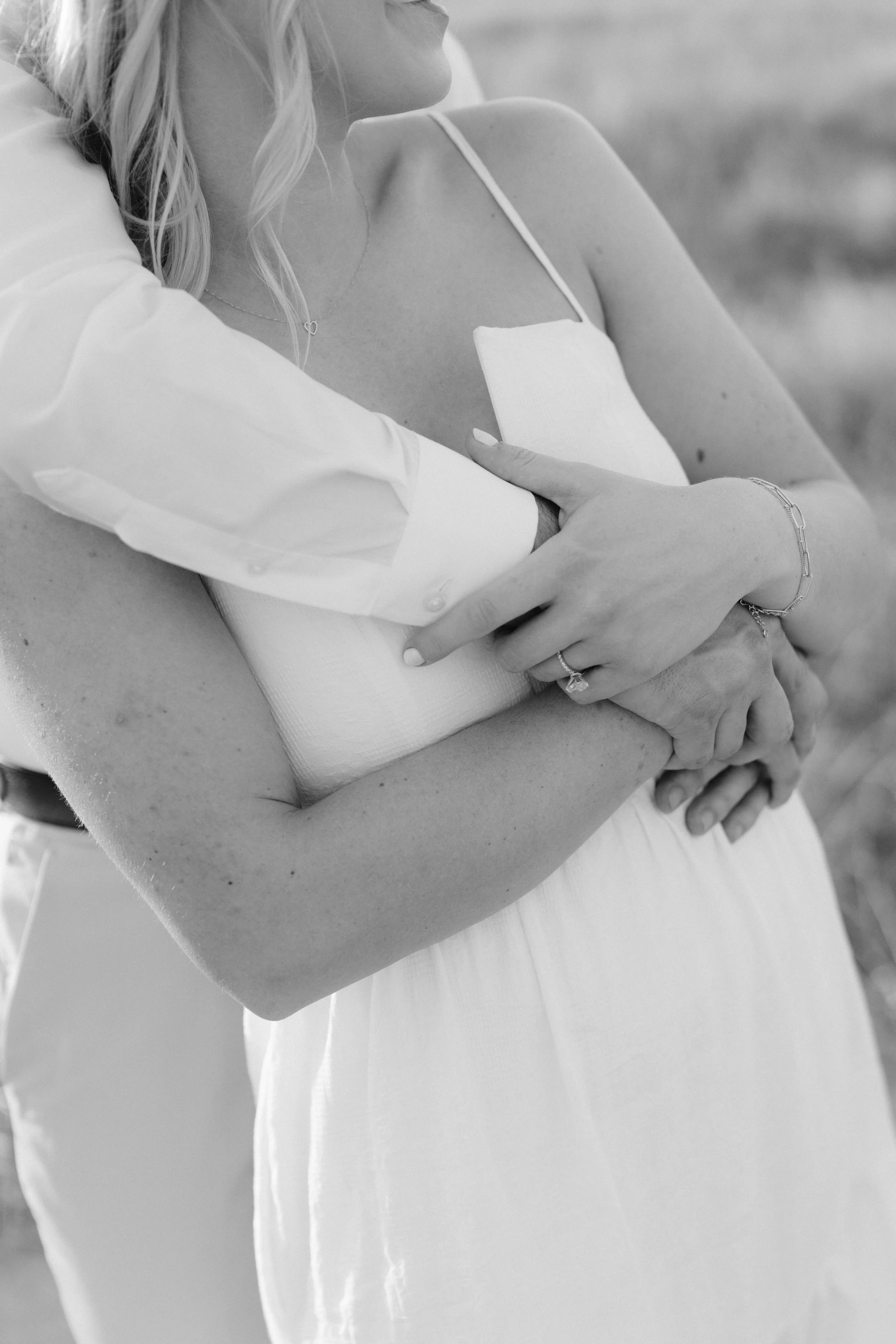 fiance wrapping arms around the shoulders of fiancee during engagement photos in downtown chicago