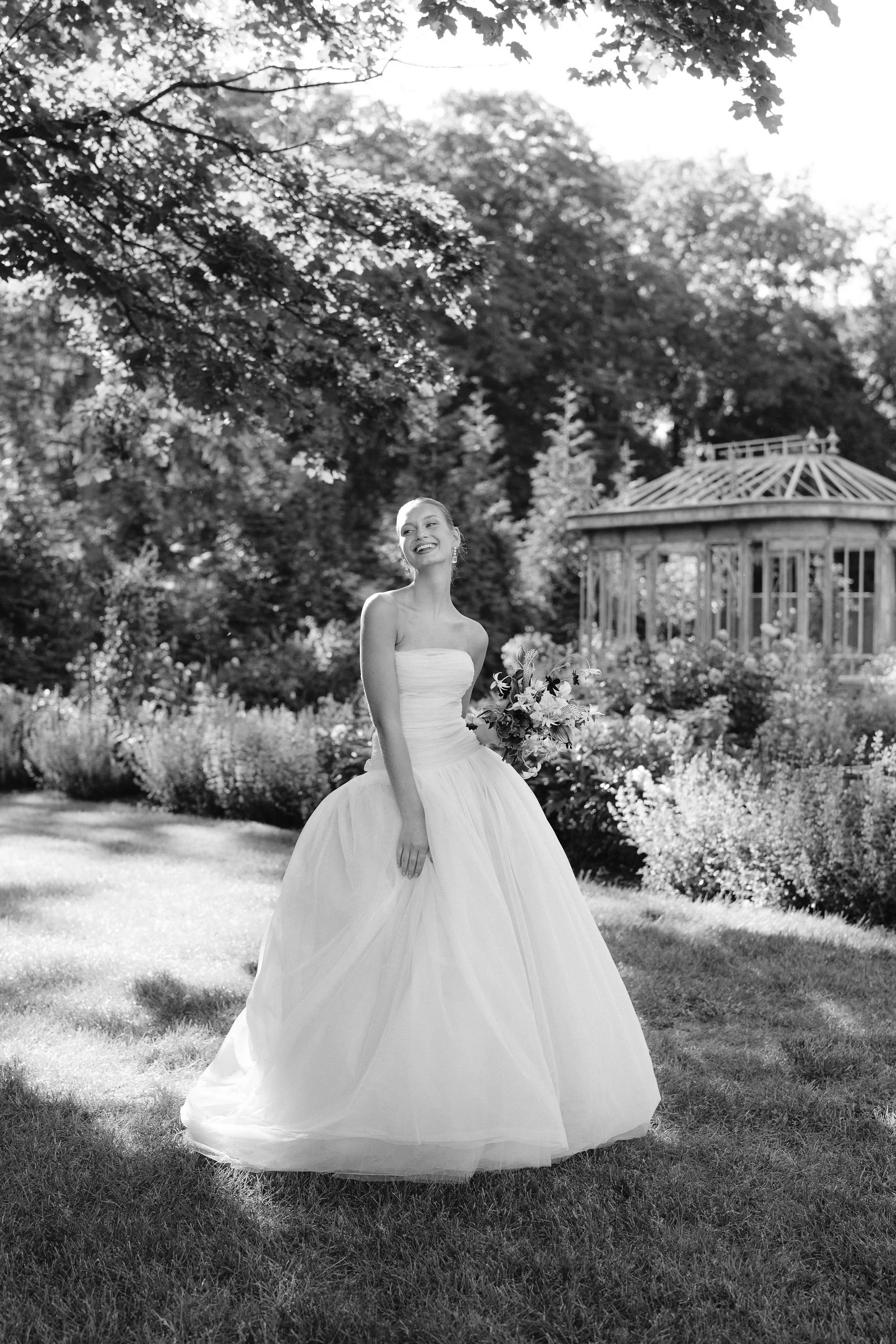 bride swaying in lein studio gown in the gardens at greencrest manor