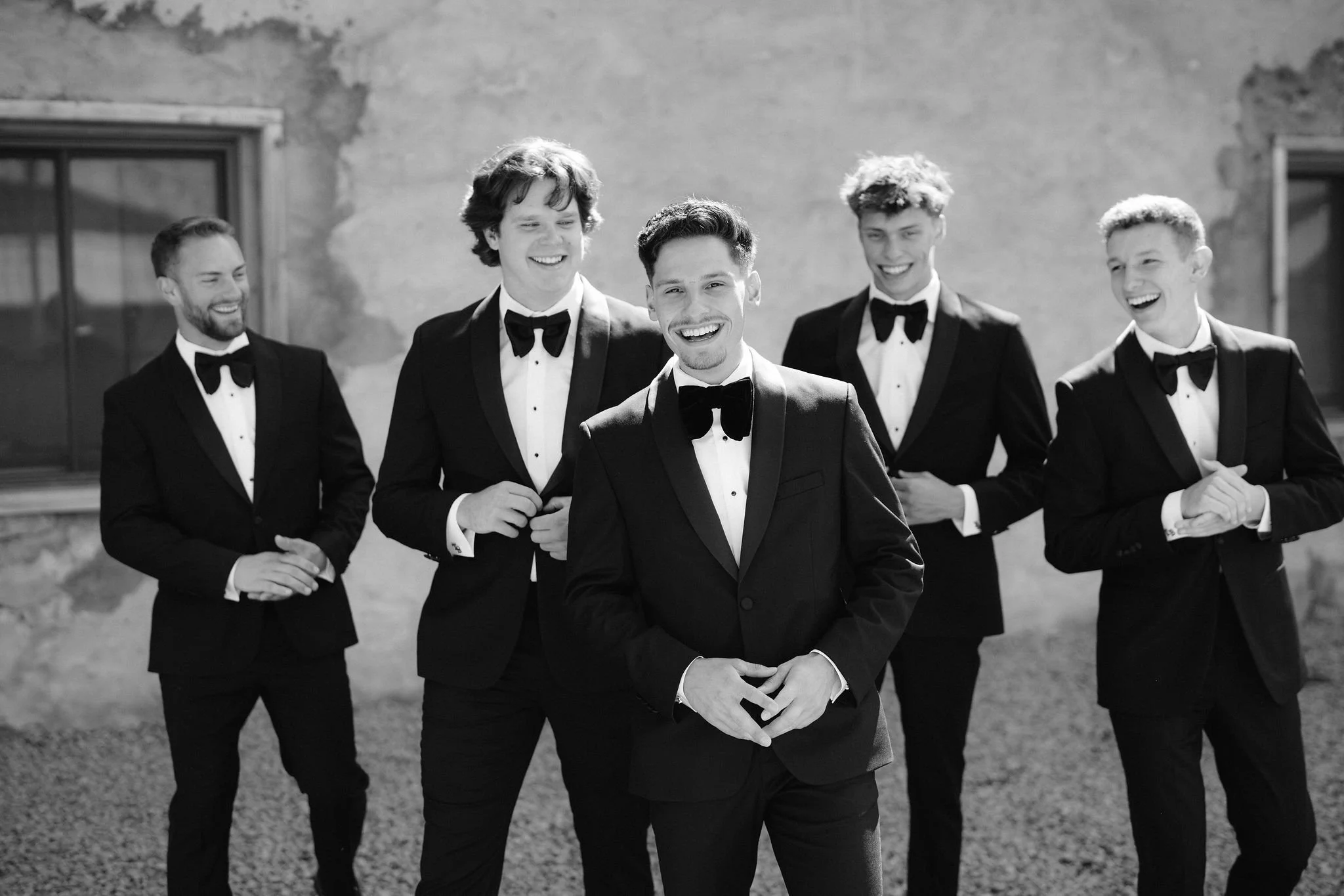 groom laughing with his groomsmen behind him