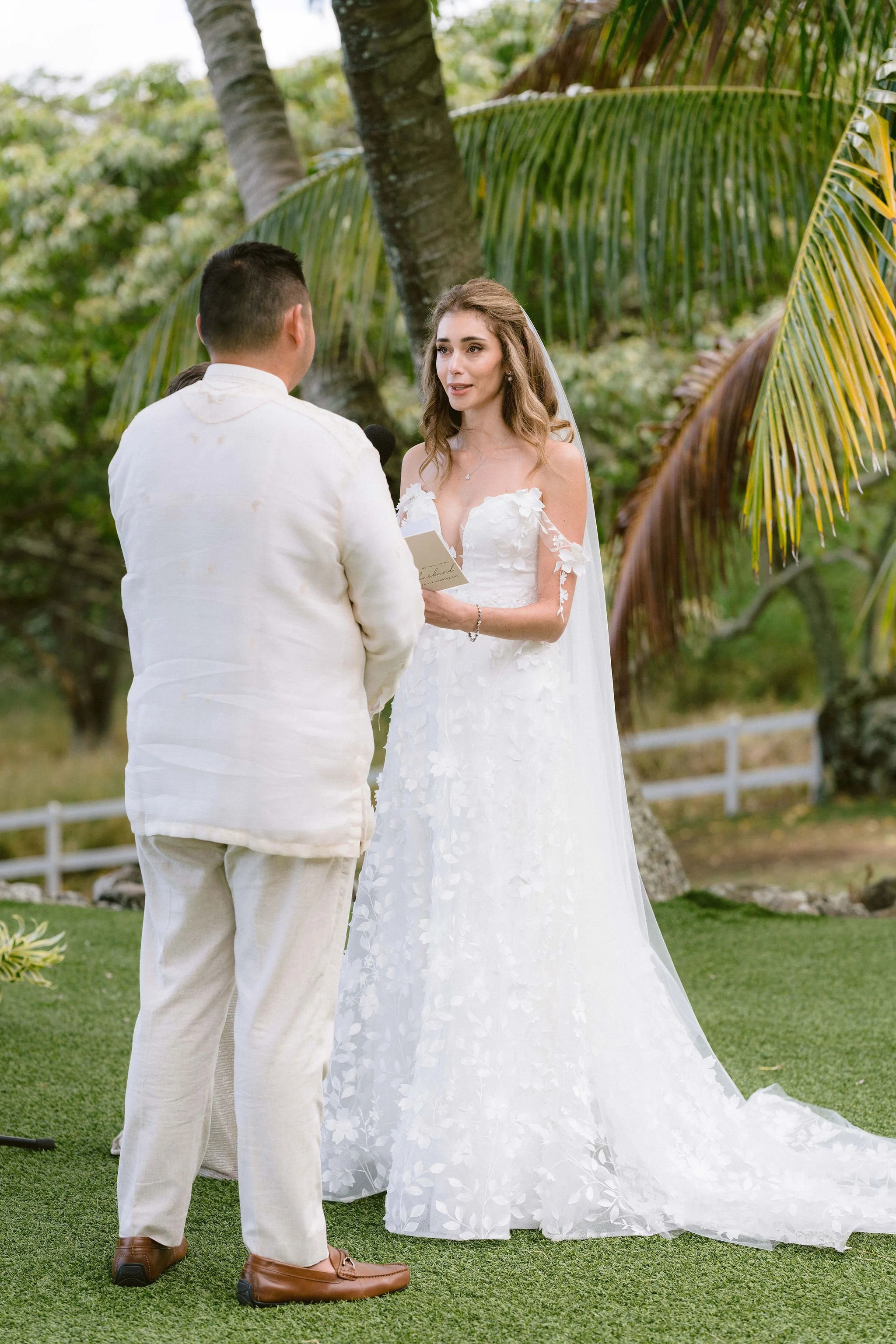 bride tearing up reading her vows to her husband at kualoa ranch wedding