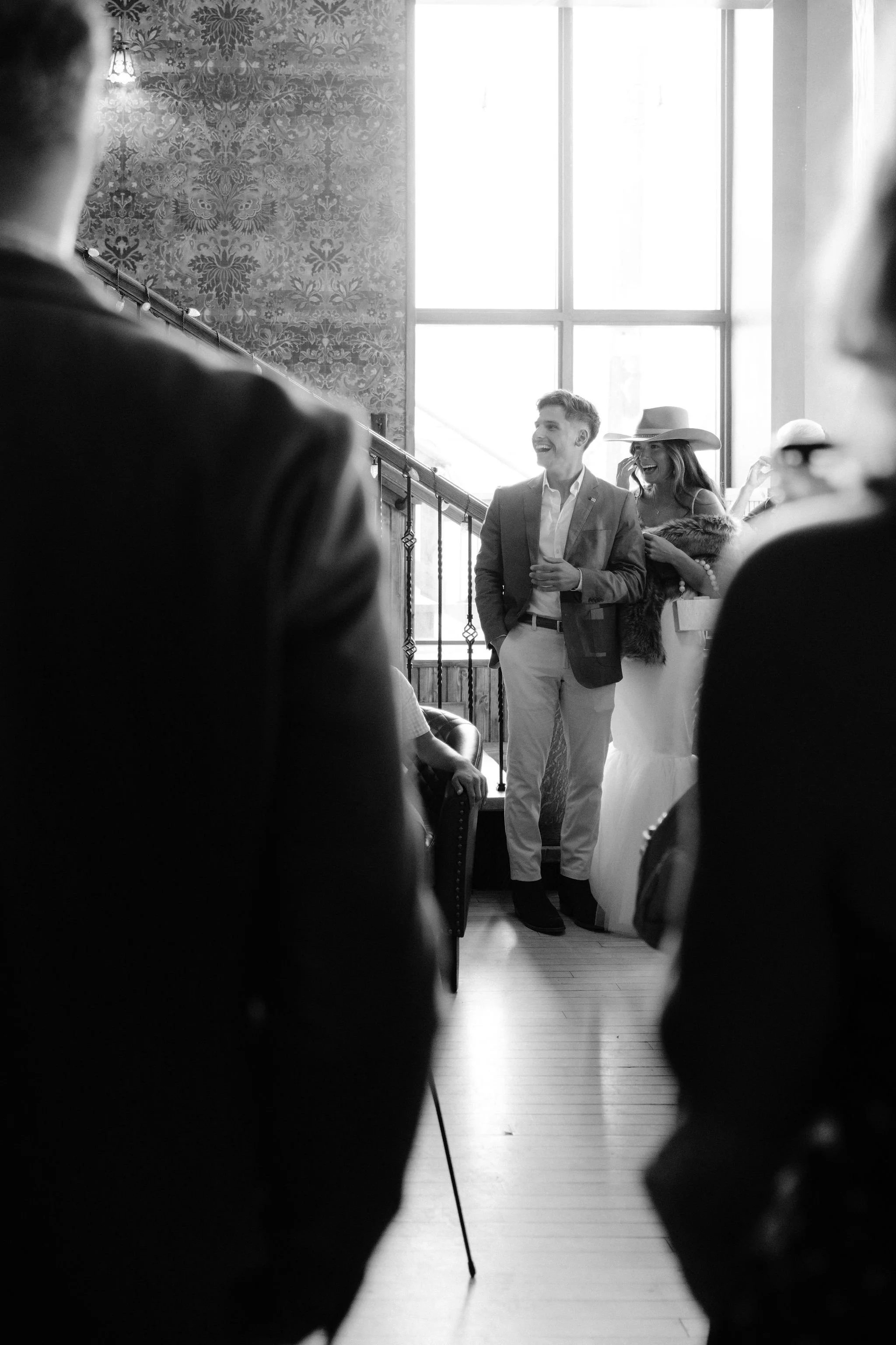 bride and groom enter down the stairs for their wedding welcome party at the pitkin hotel